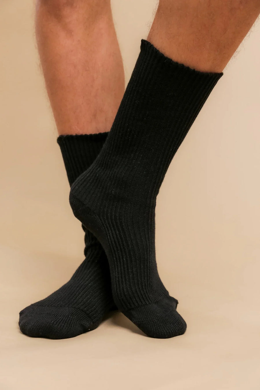 Person wearing ribbed black crew socks made from organic cotton for sensitive skin