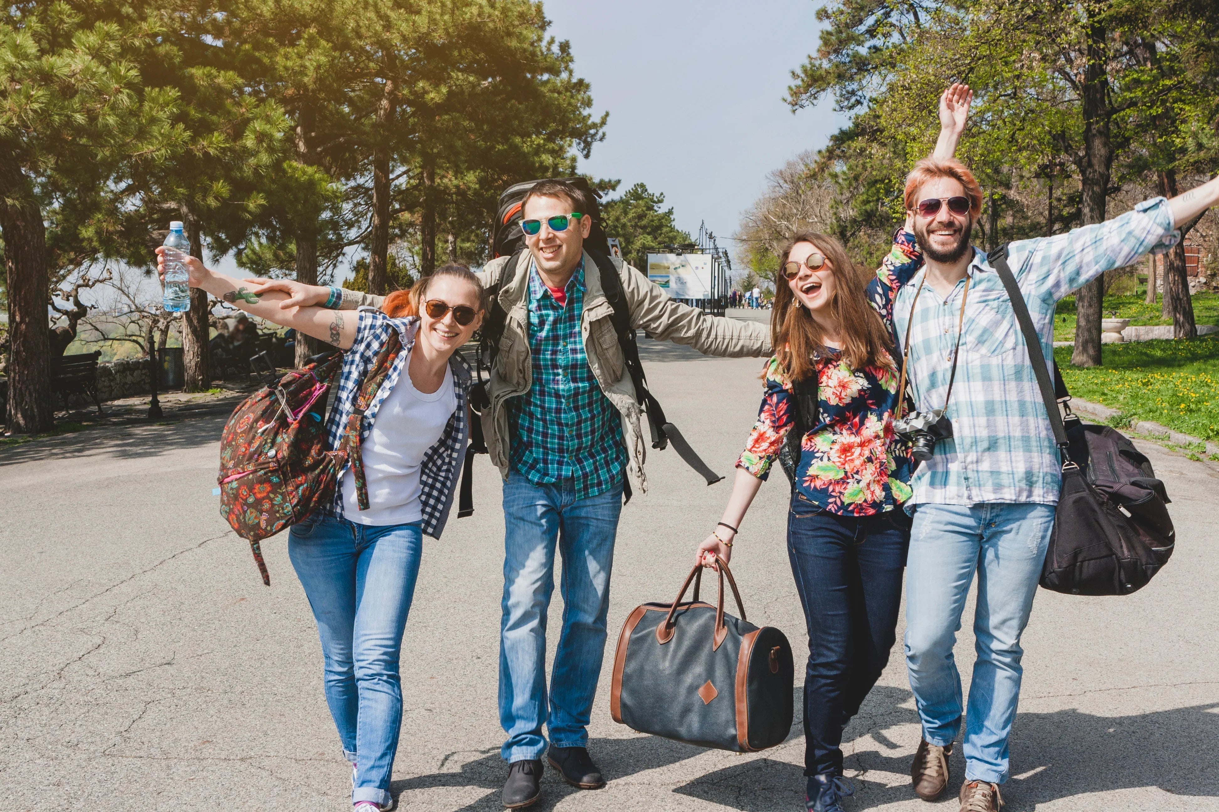 Group of friends in casual spring clothing enjoying a sunny day outdoors with backpacks