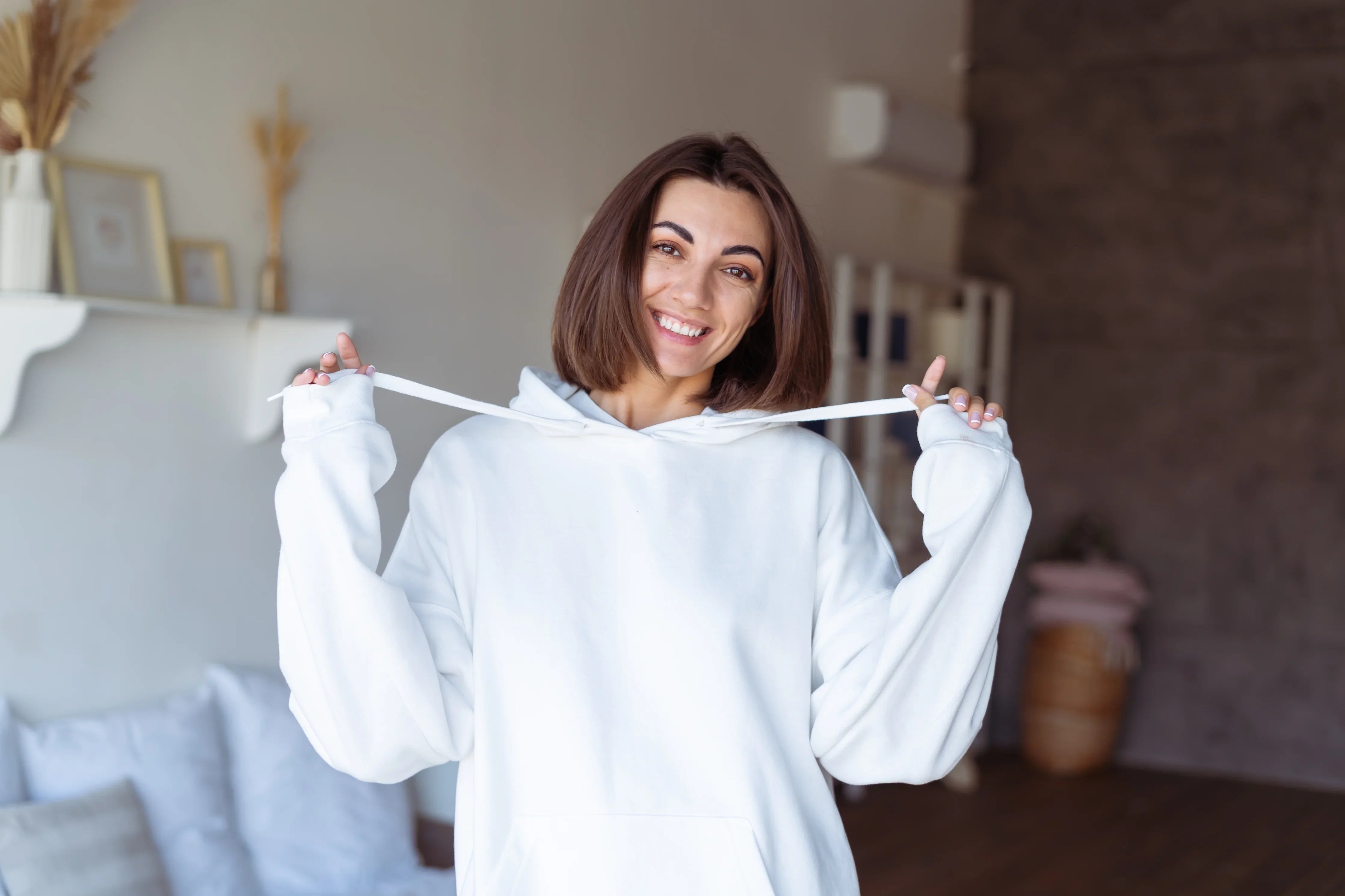 Smiling woman in allergy-free white cotton hoodie at home bedroom, hypoallergenic apparel
