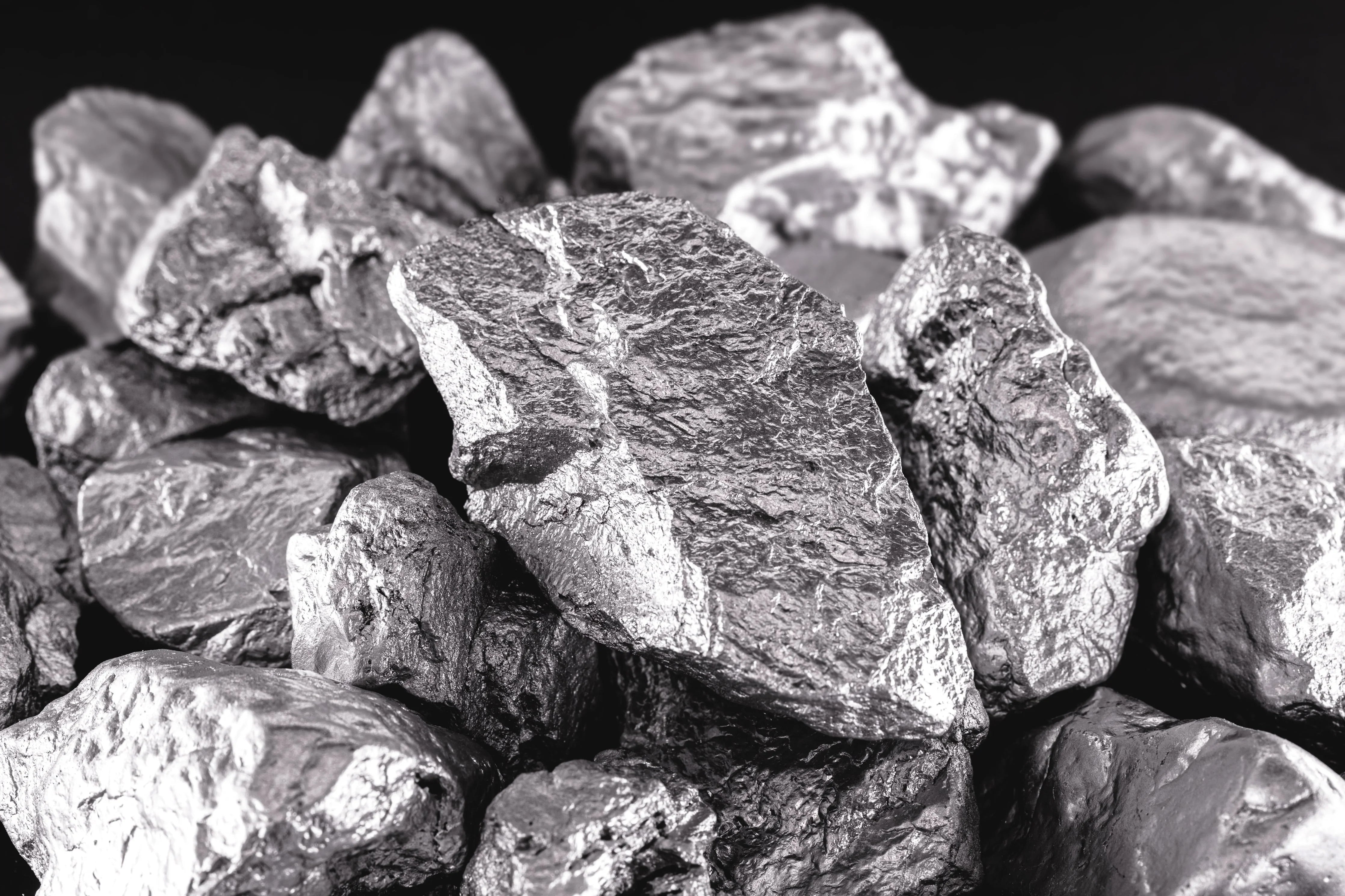 Close-up of raw metallic grey cobalt ore rocks, allergy-free apparel material context