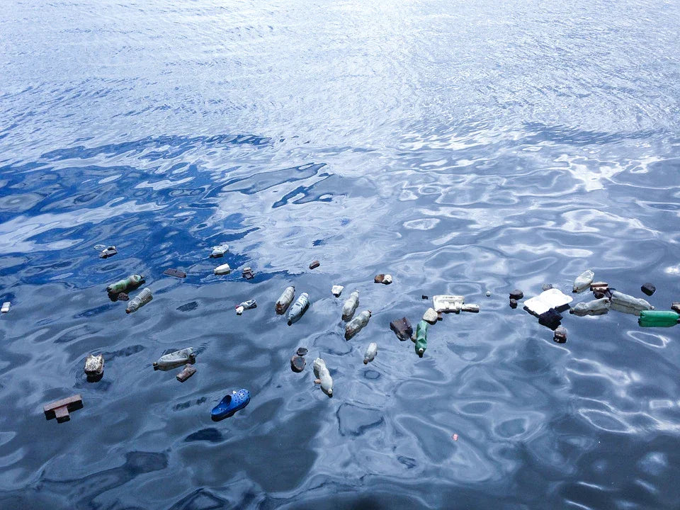 Plastic bottles and debris floating on polluted water surface, highlighting environmental issues