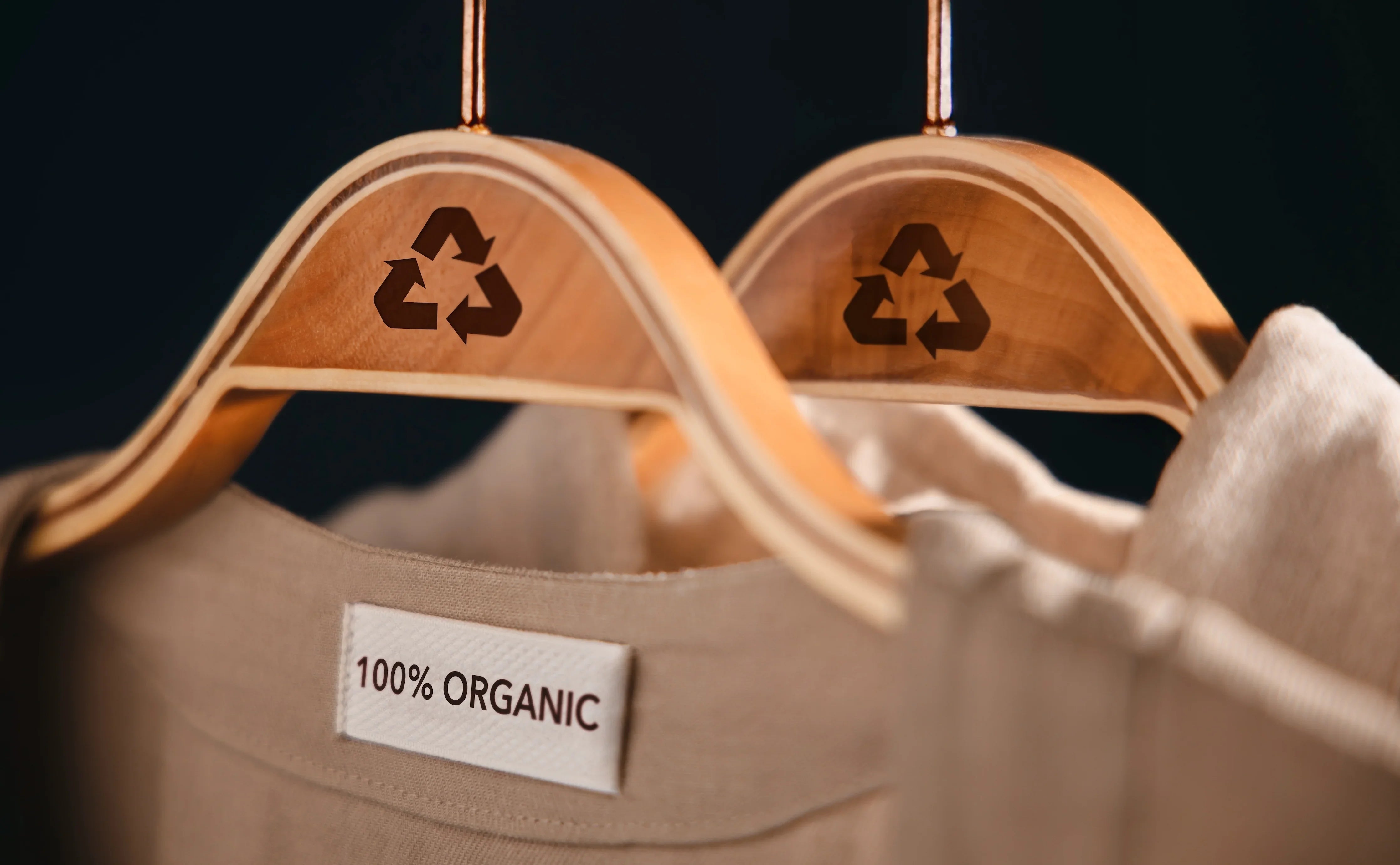 100% organic cotton shirt on wooden hanger with recycling symbol, hypoallergenic apparel