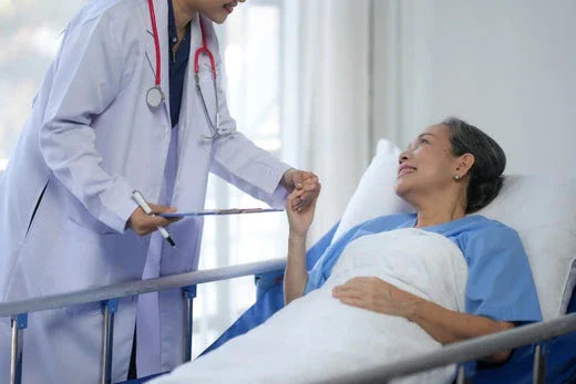 Doctor comforting patient in hospital bed, patient wearing blue medical gown