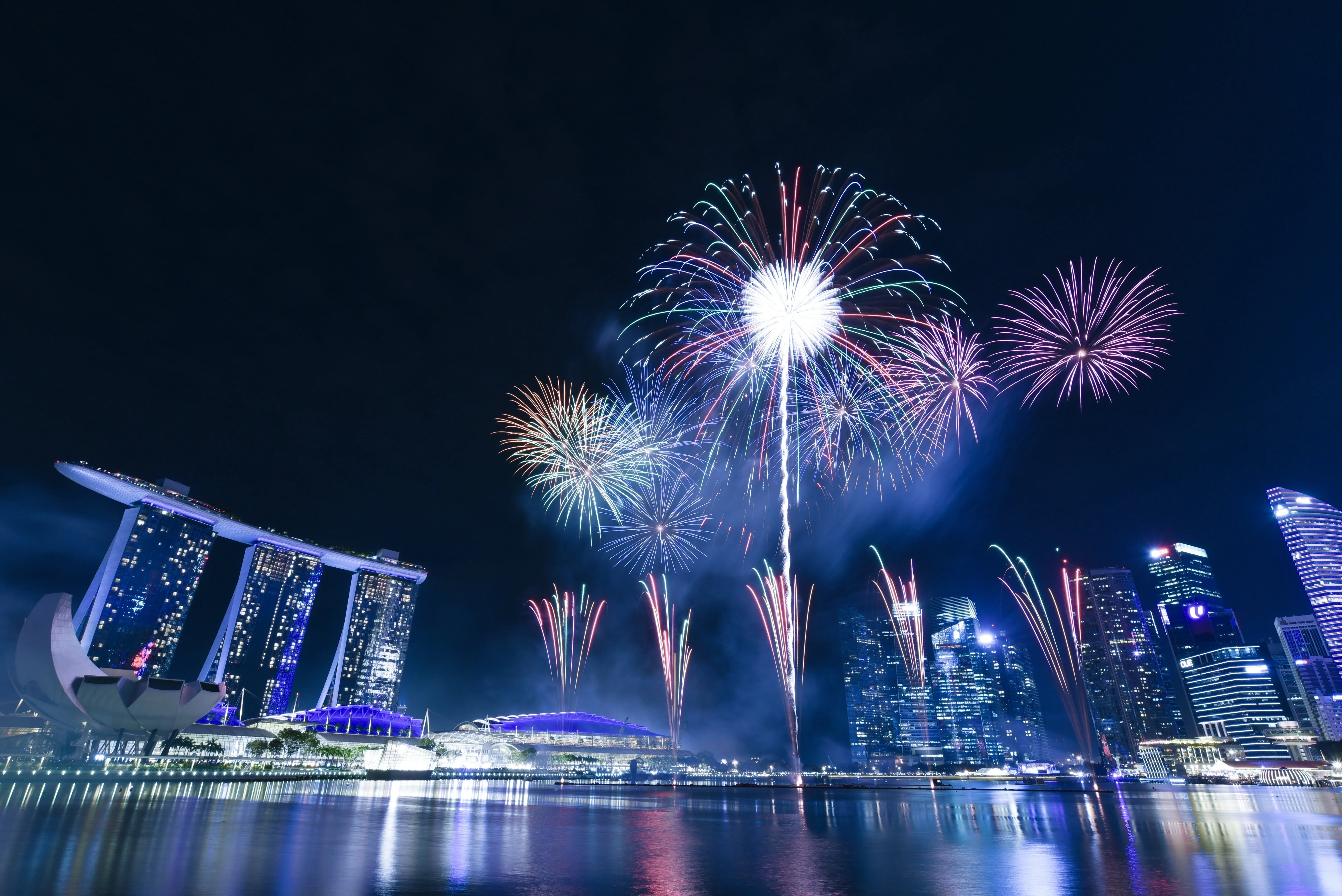 Colorful fireworks over Singapore skyline at night with Marina Bay Sands and skyscrapers
