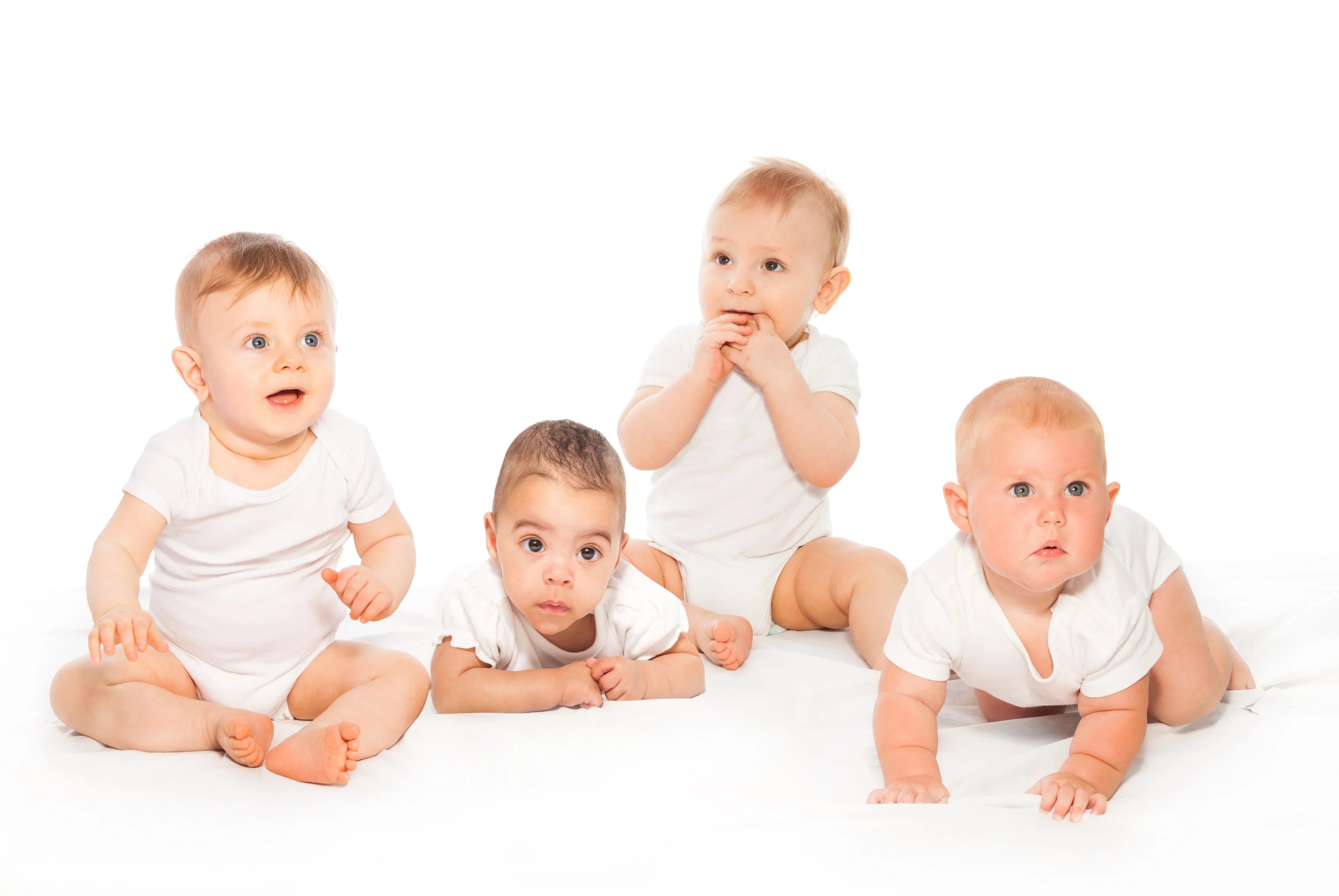 Four babies in white allergy-free cotton bodysuits sitting on a white background