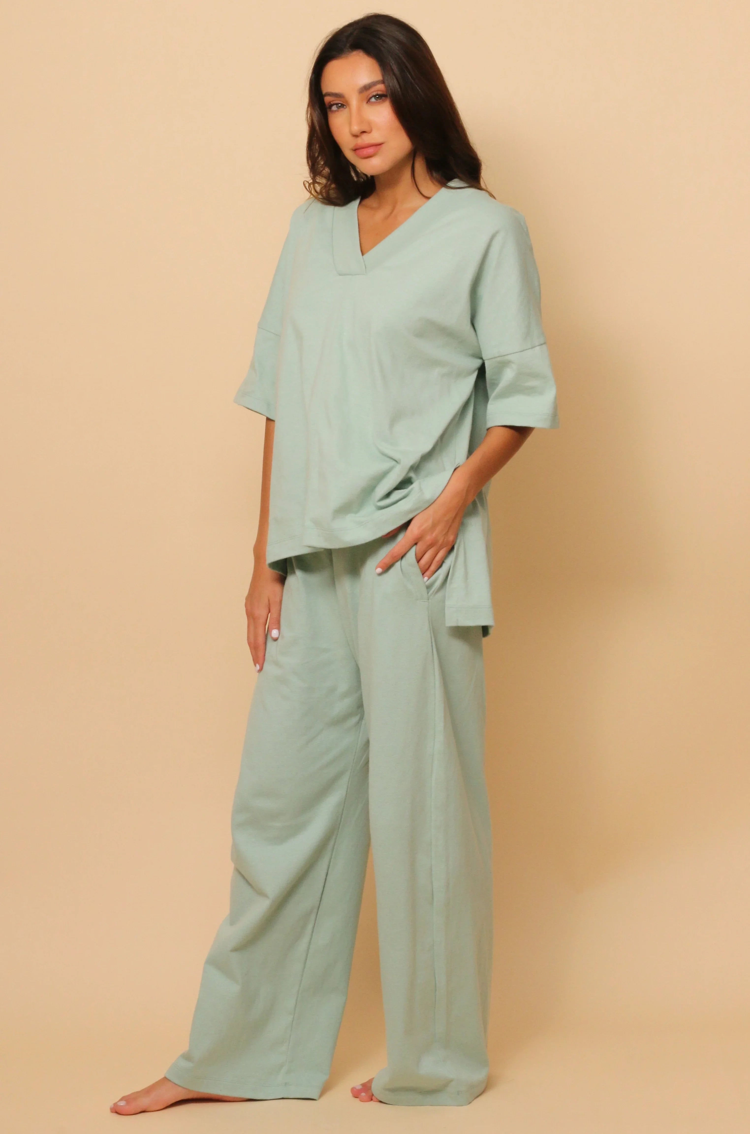 Woman wearing light green hypoallergenic cotton loungewear from Cottonique