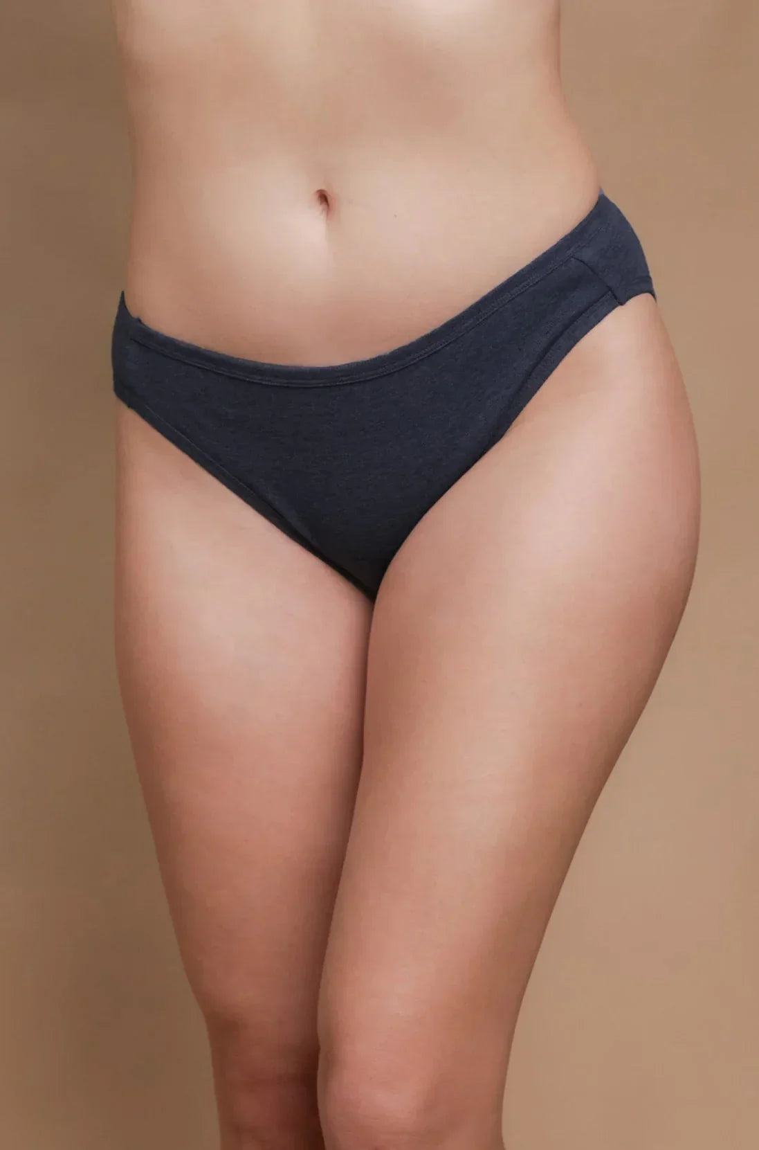 Woman wearing dark gray allergy-free cotton bikini underwear on neutral background