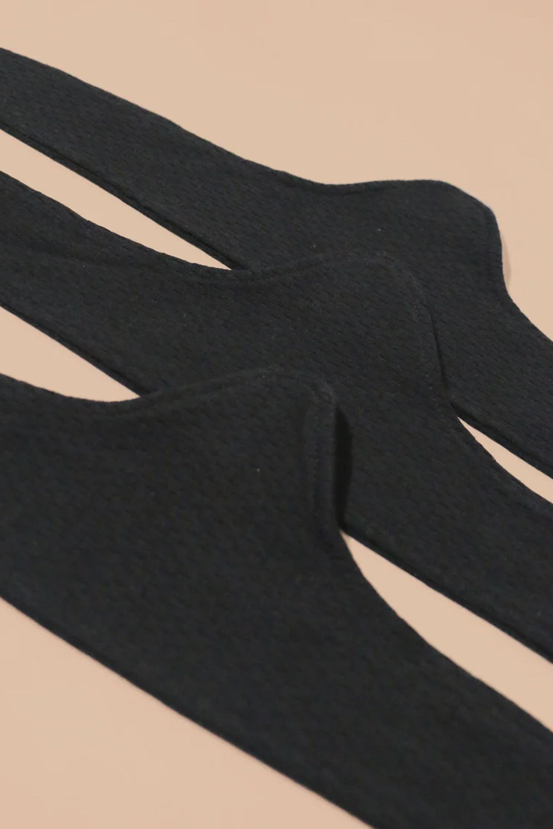 Three black Cottonique Women's Hypoallergenic Under Bust Liners arranged diagonally.