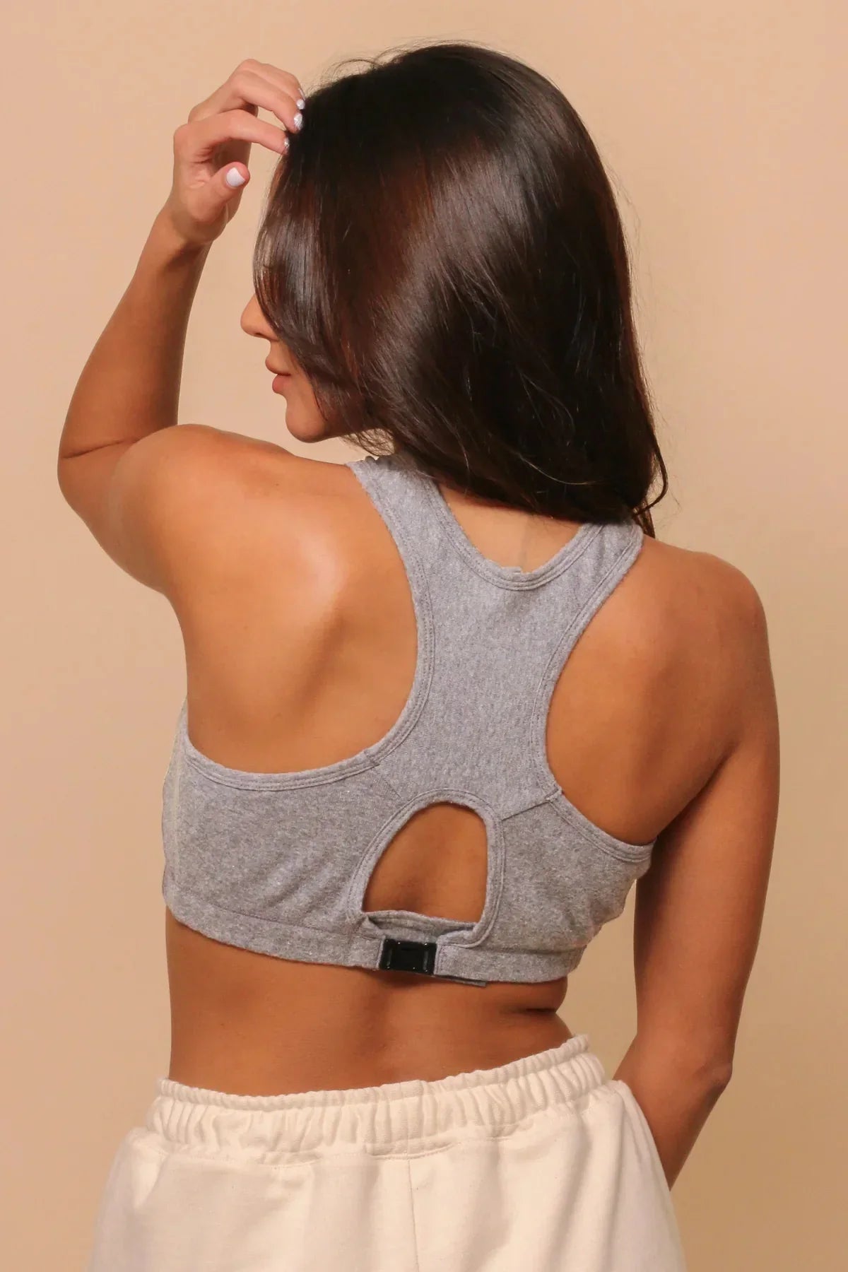 Woman wearing a grey organic cotton racerback bra, latex-free, shown from the back.