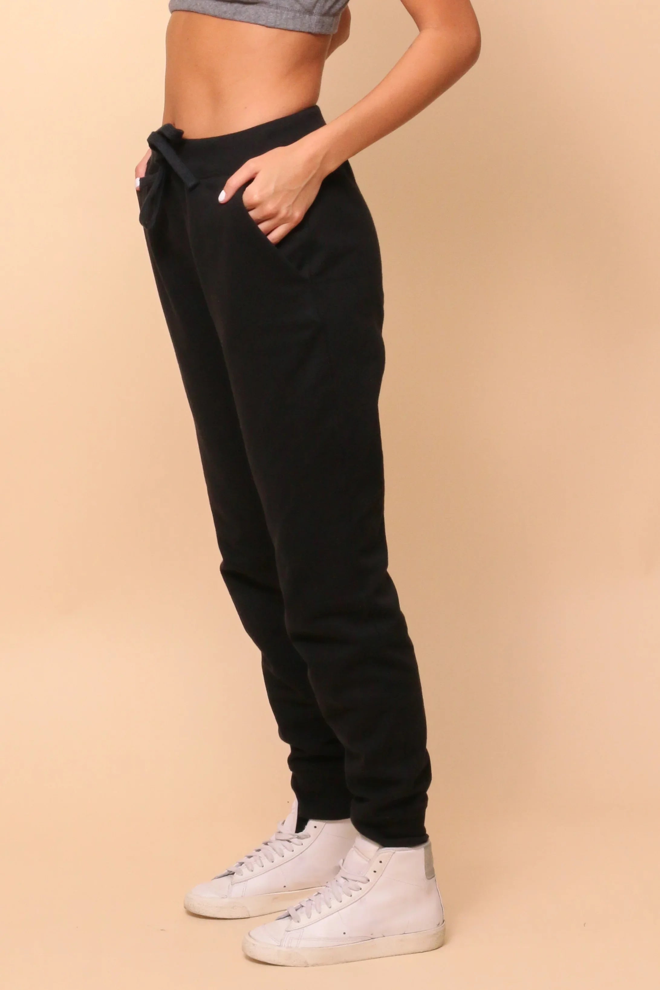 Woman wearing Cottonique black hypoallergenic jogger pants and white sneakers