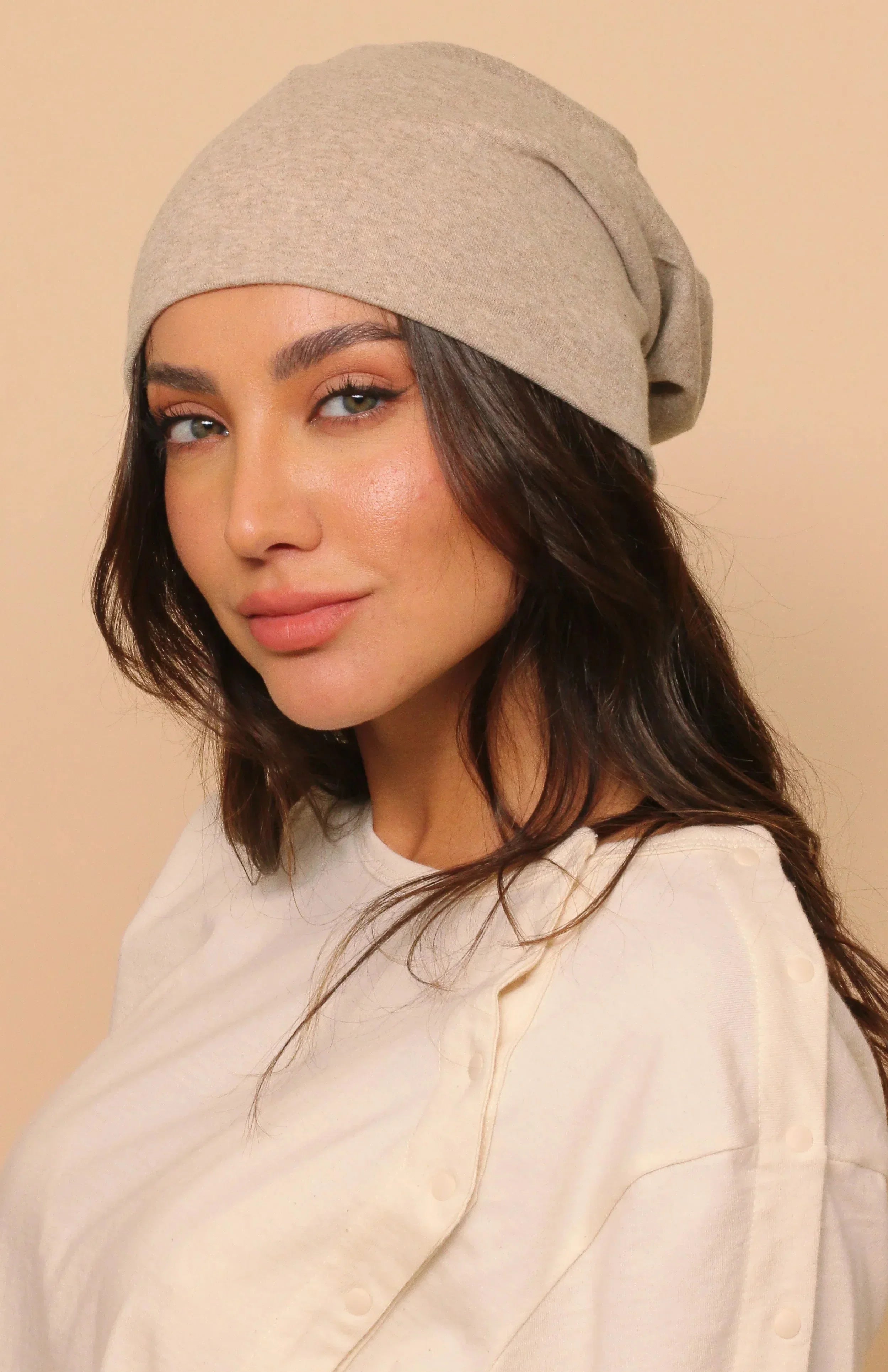 Woman wearing a light beige organic cotton beanie and an off-white allergy-friendly shirt