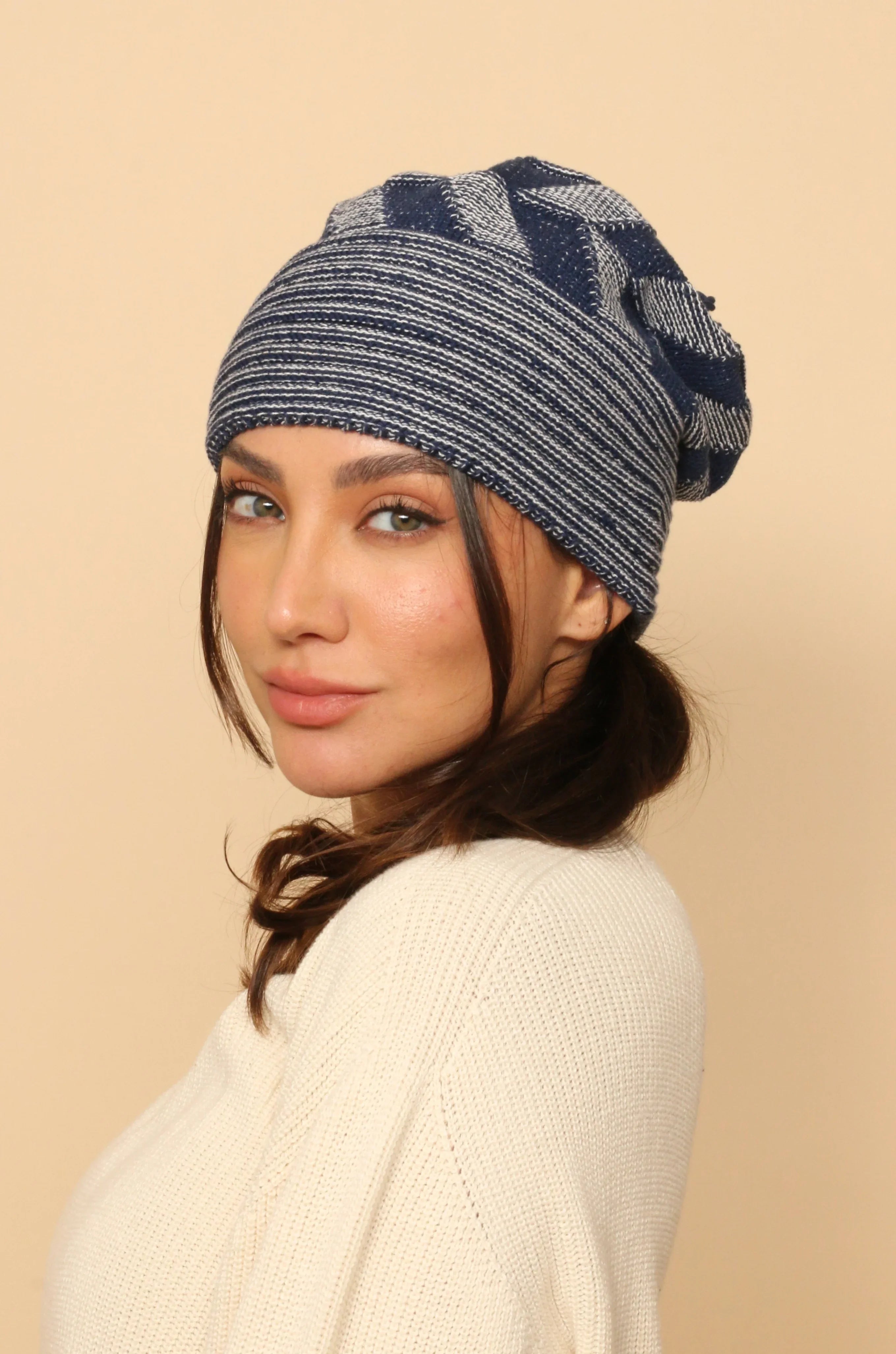 Woman wearing blue and white striped knit cotton hat and off-white textured sweater
