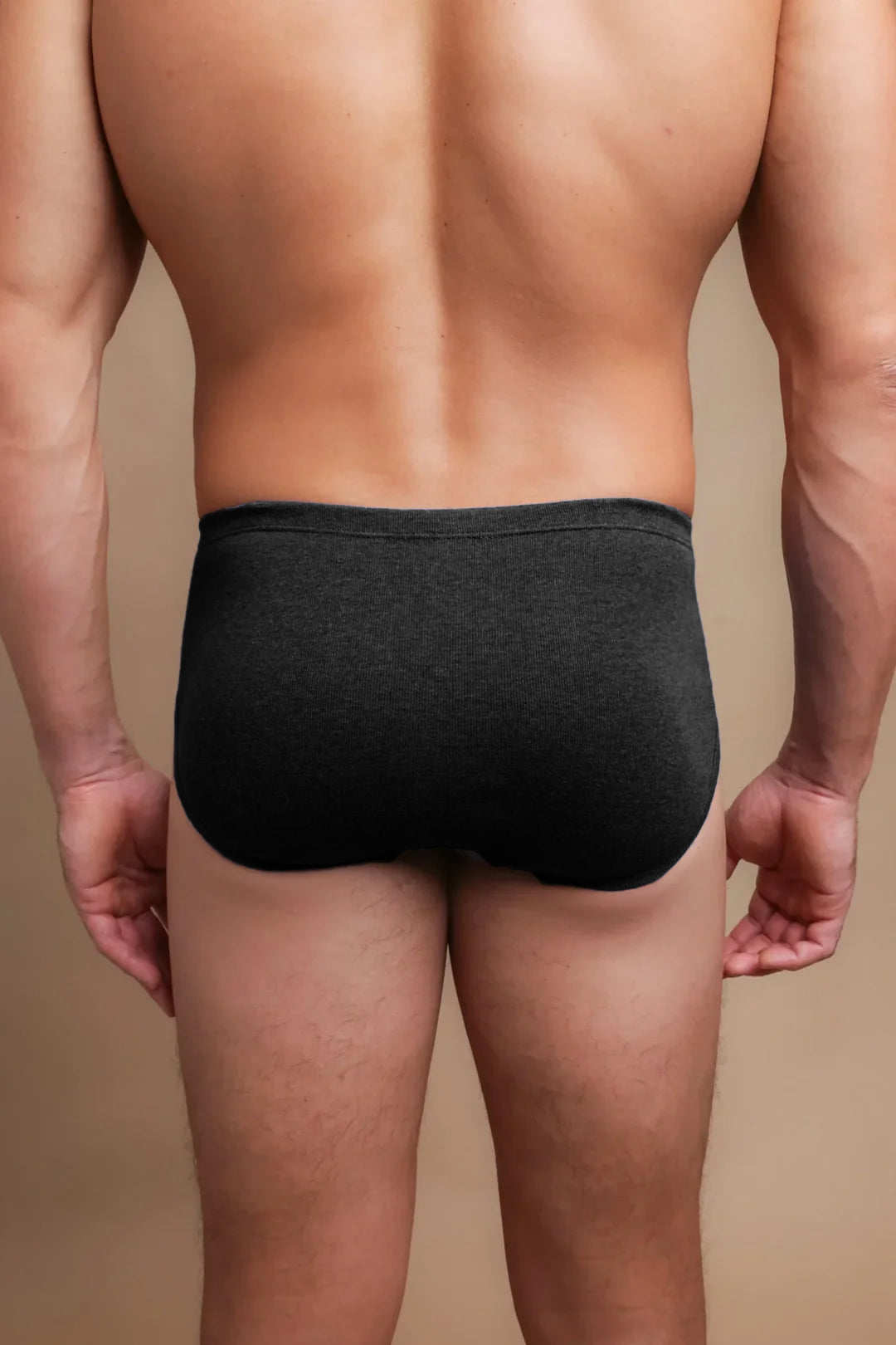 Back view of a man wearing dark hypoallergenic cotton briefs from Cottonique