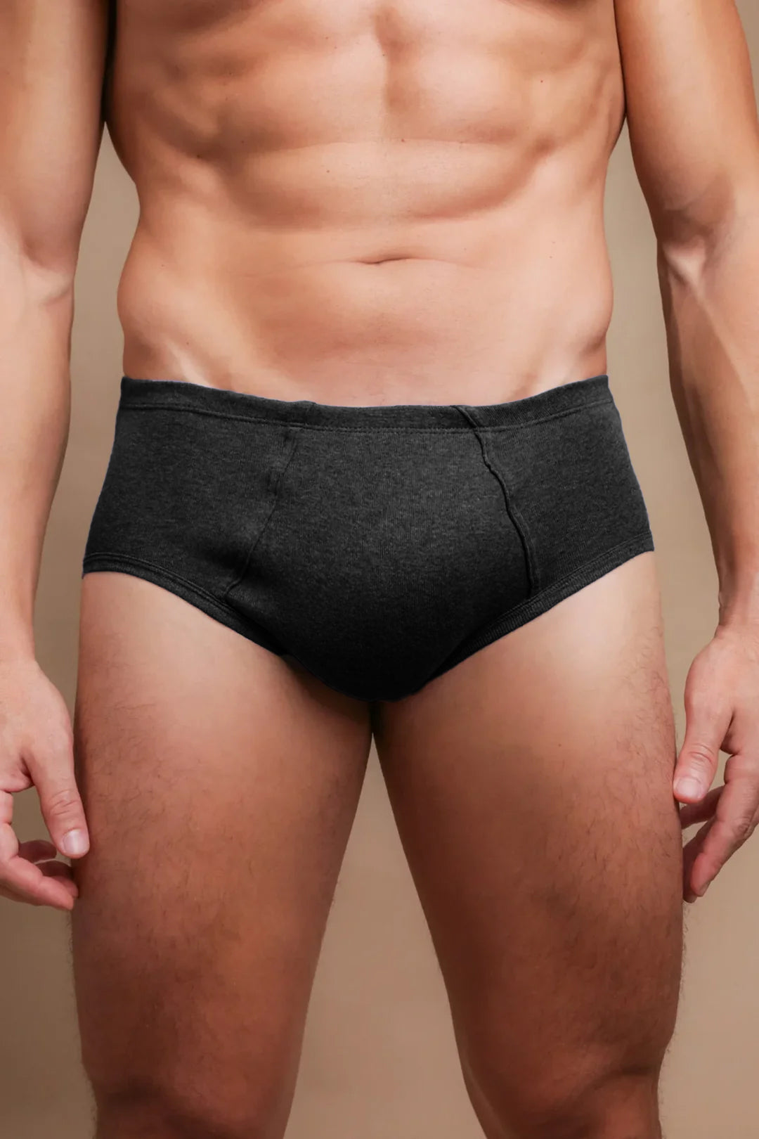 Man wearing dark hypoallergenic cotton briefs from Cottonique on neutral background