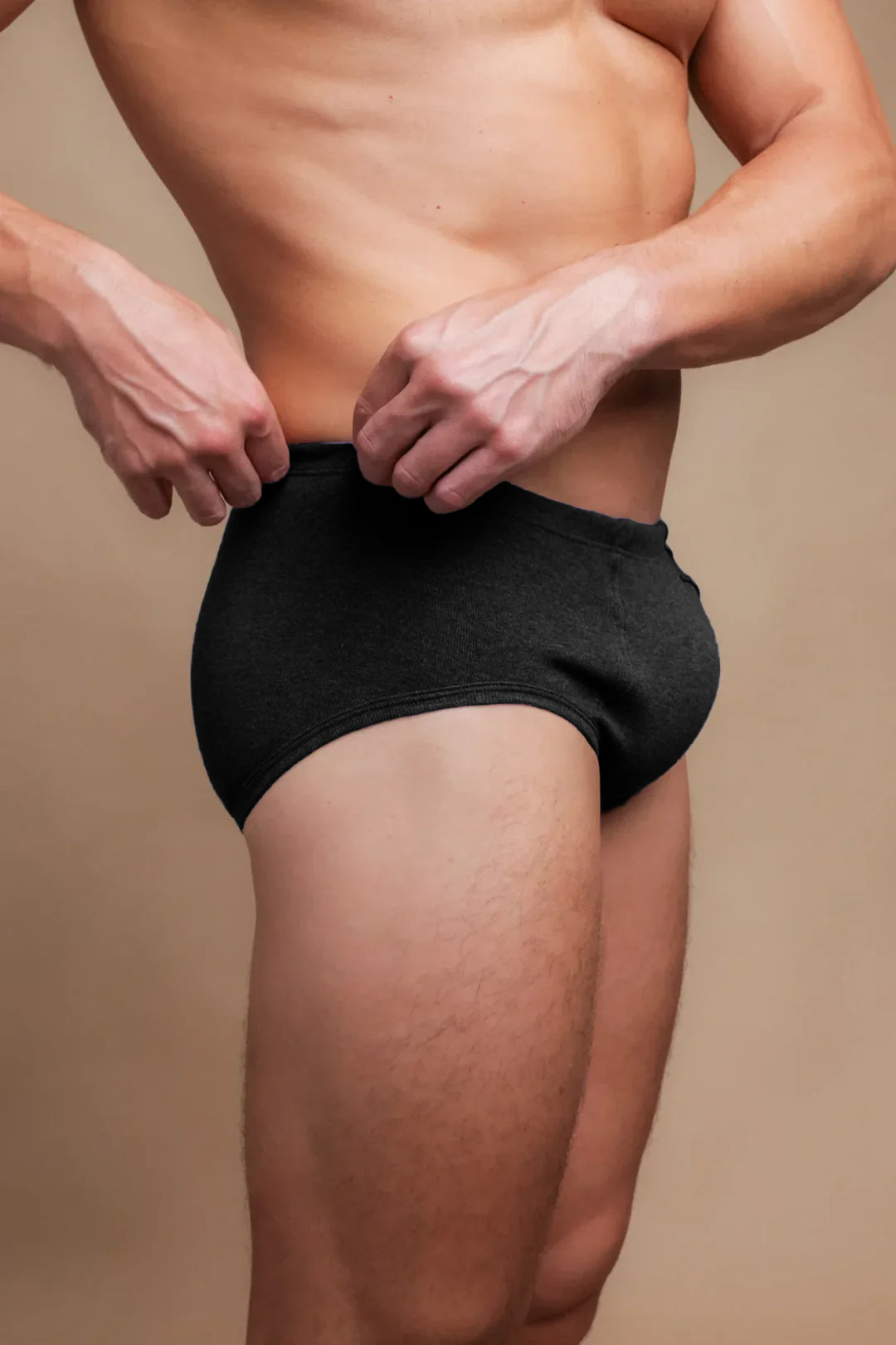 Man wearing black Cottonique hypoallergenic briefs against a neutral background