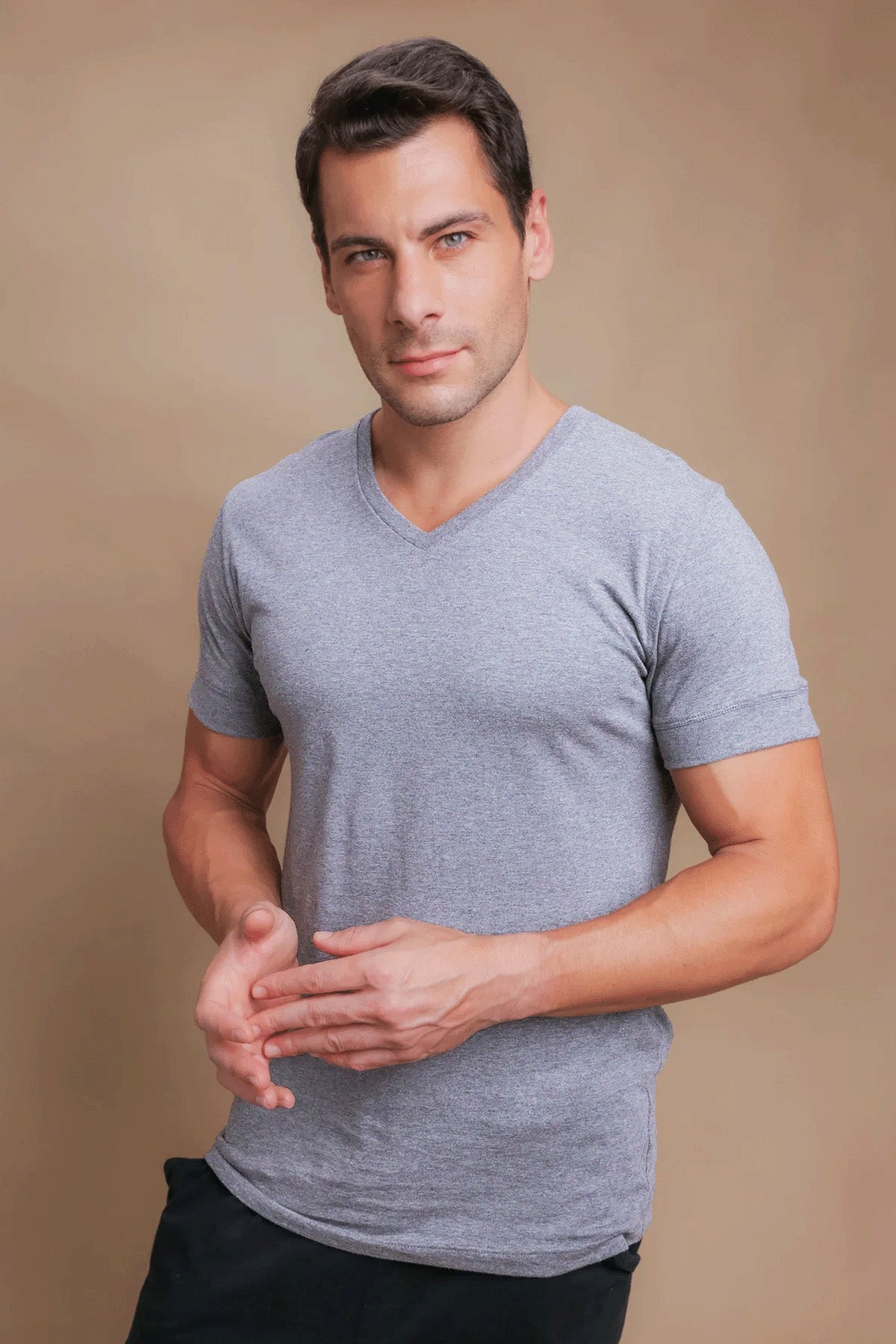 Man wearing allergy-free grey cotton V-neck T-shirt by Cottonique, neutral background
