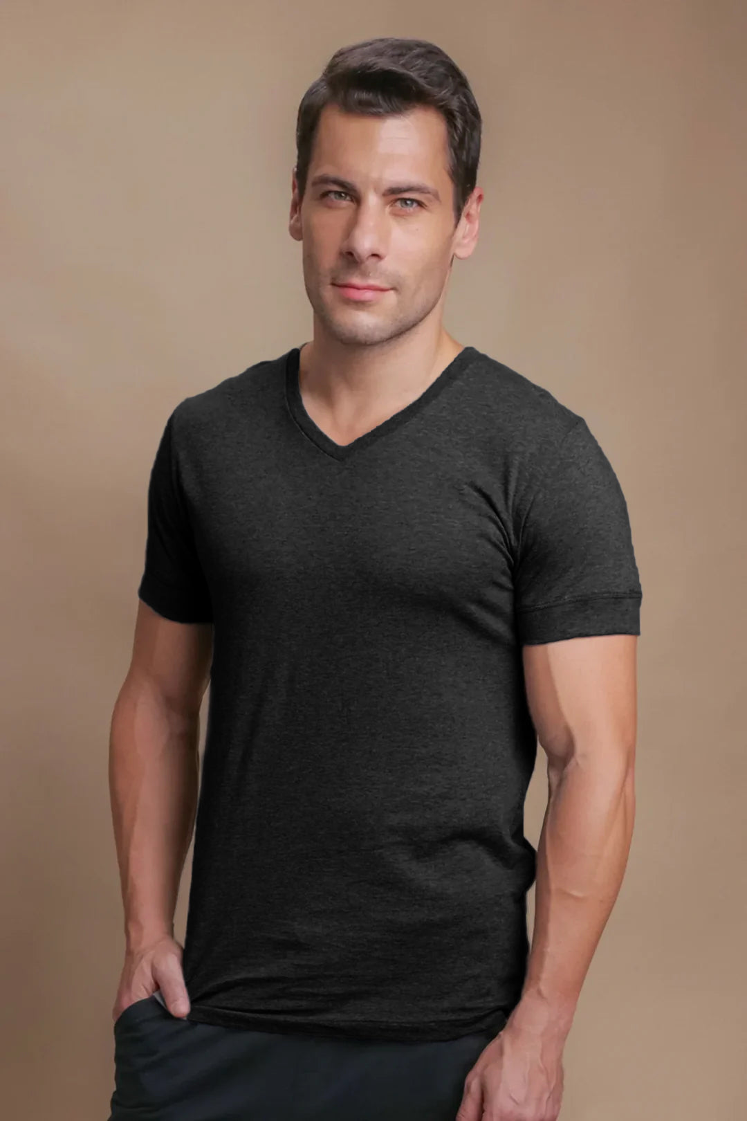 Man wearing black hypoallergenic V-neck T-shirt from Cottonique, front view, beige background