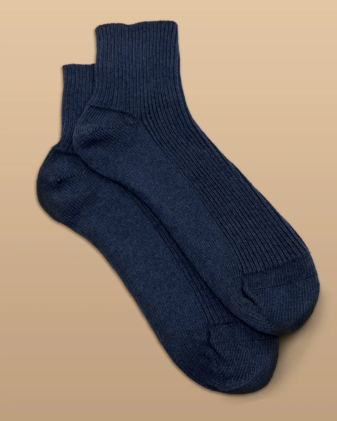 Navy blue hypoallergenic cotton socks from Cottonique against a beige background