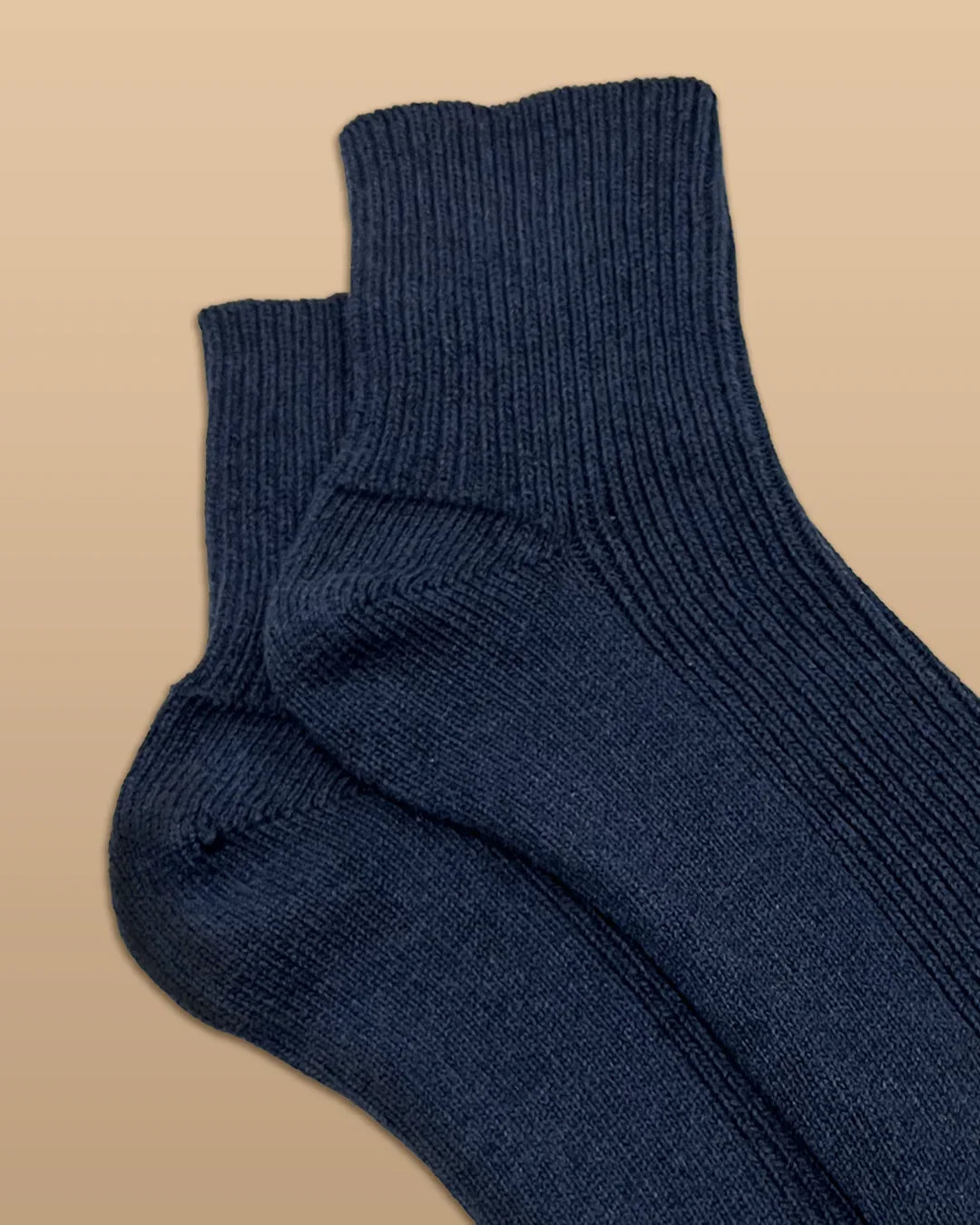 Navy blue hypoallergenic cotton socks from Cottonique on a beige background