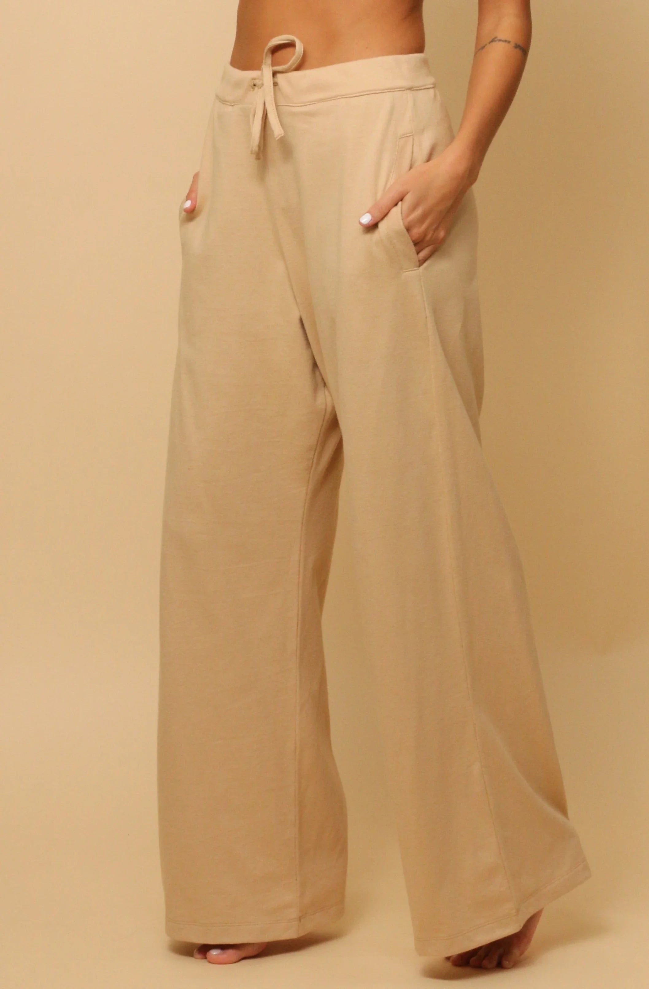 Woman wearing beige hypoallergenic cotton wide-leg lounge pants with drawstring waist