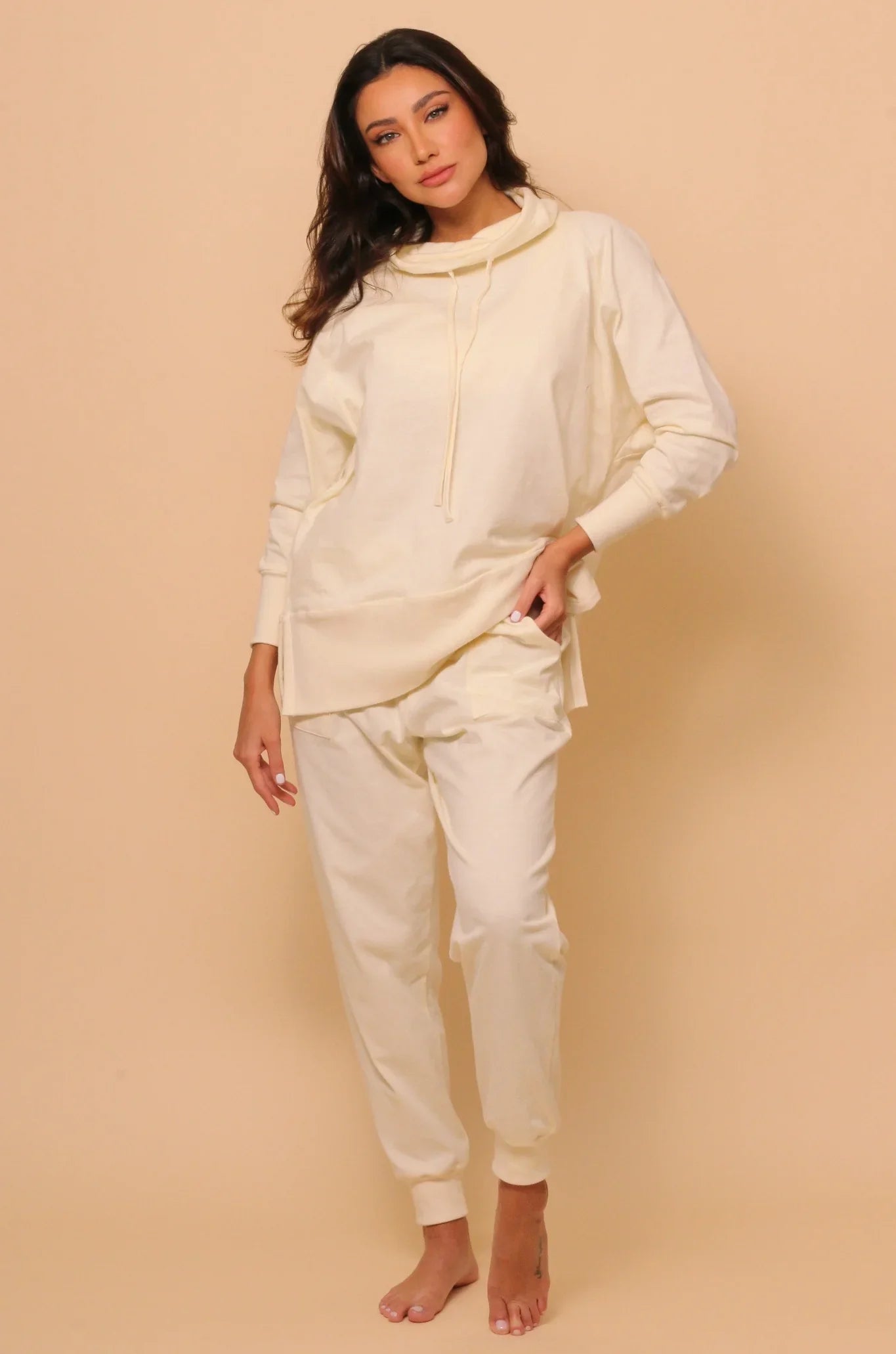 Woman wearing allergy-free Cottonique hypoallergenic cream lounge set on beige background