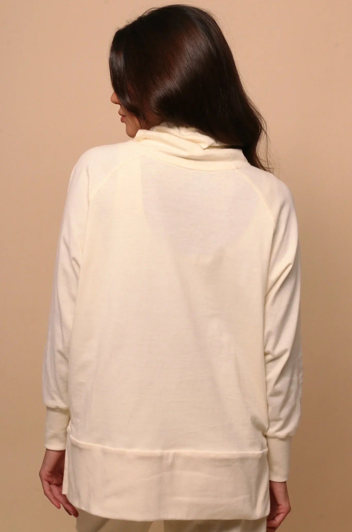 Woman wearing cream hypoallergenic Cottonique pullover, back view, allergy-free apparel
