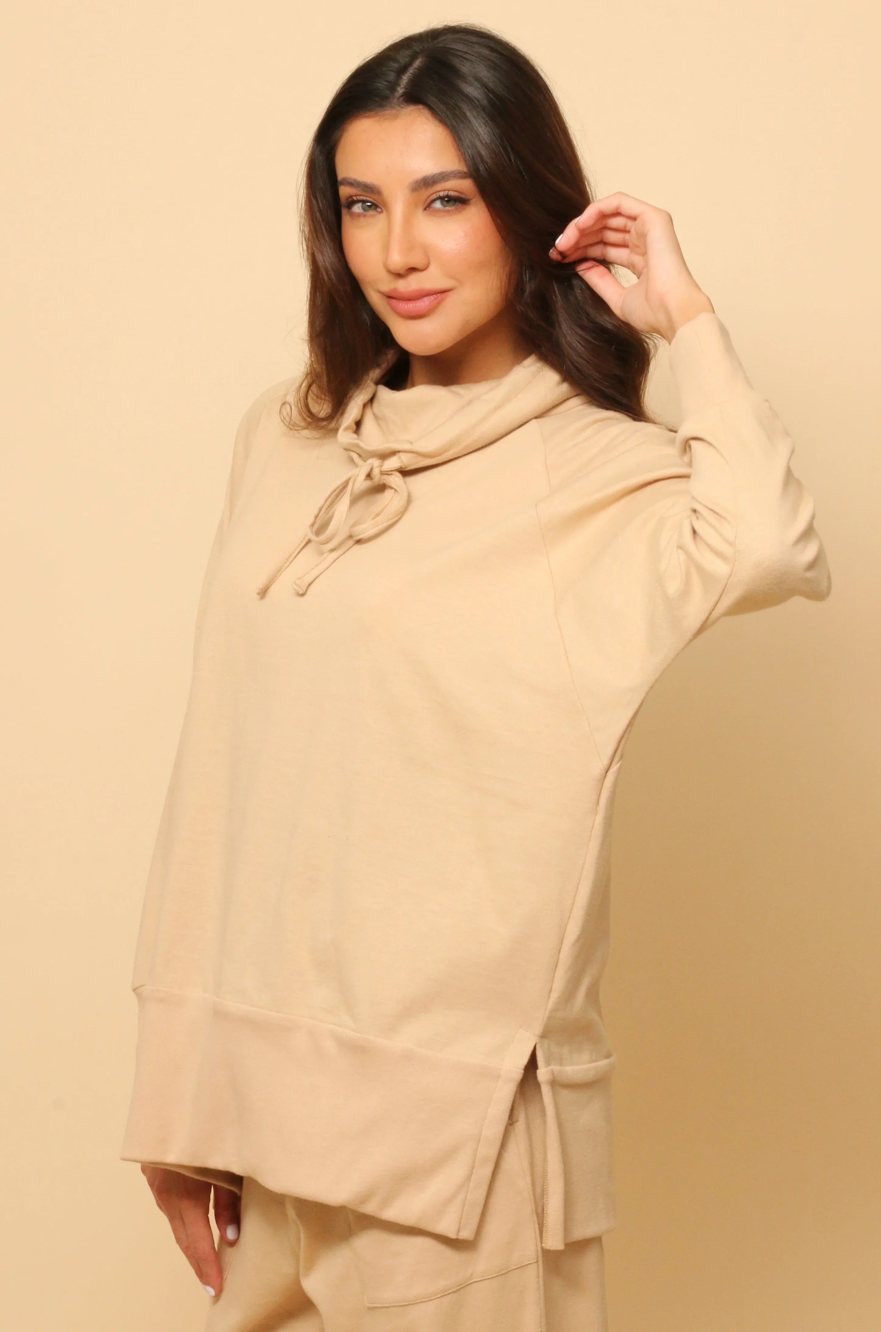 Woman wearing beige hypoallergenic cotton hoodie from Cottonique on neutral background