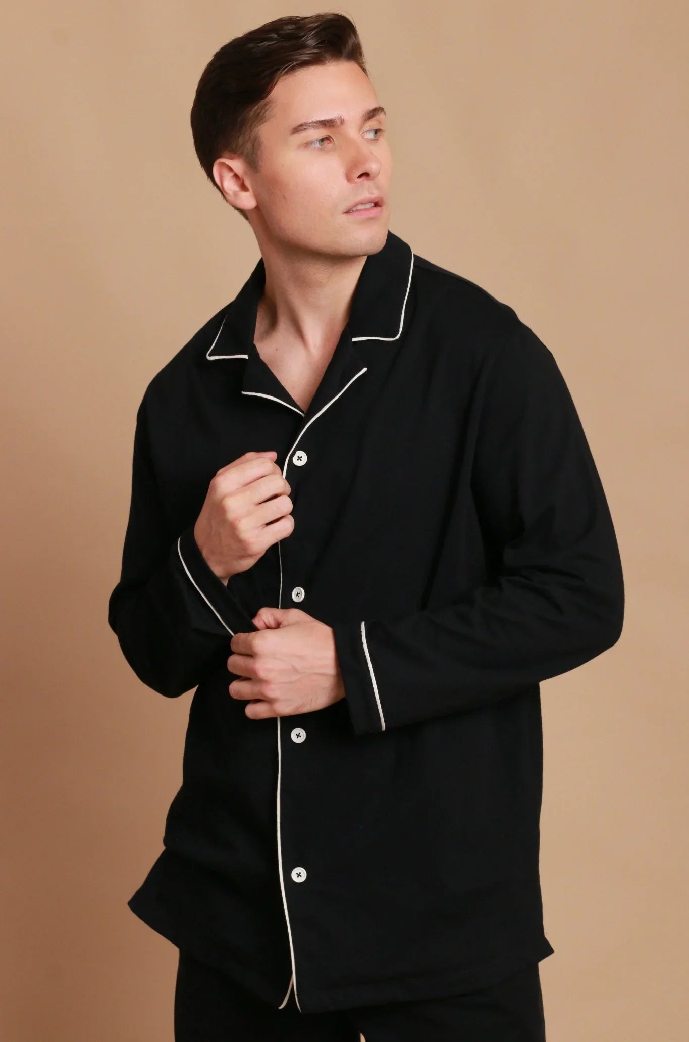 Man wearing black hypoallergenic cotton pajama shirt with white piping by Cottonique