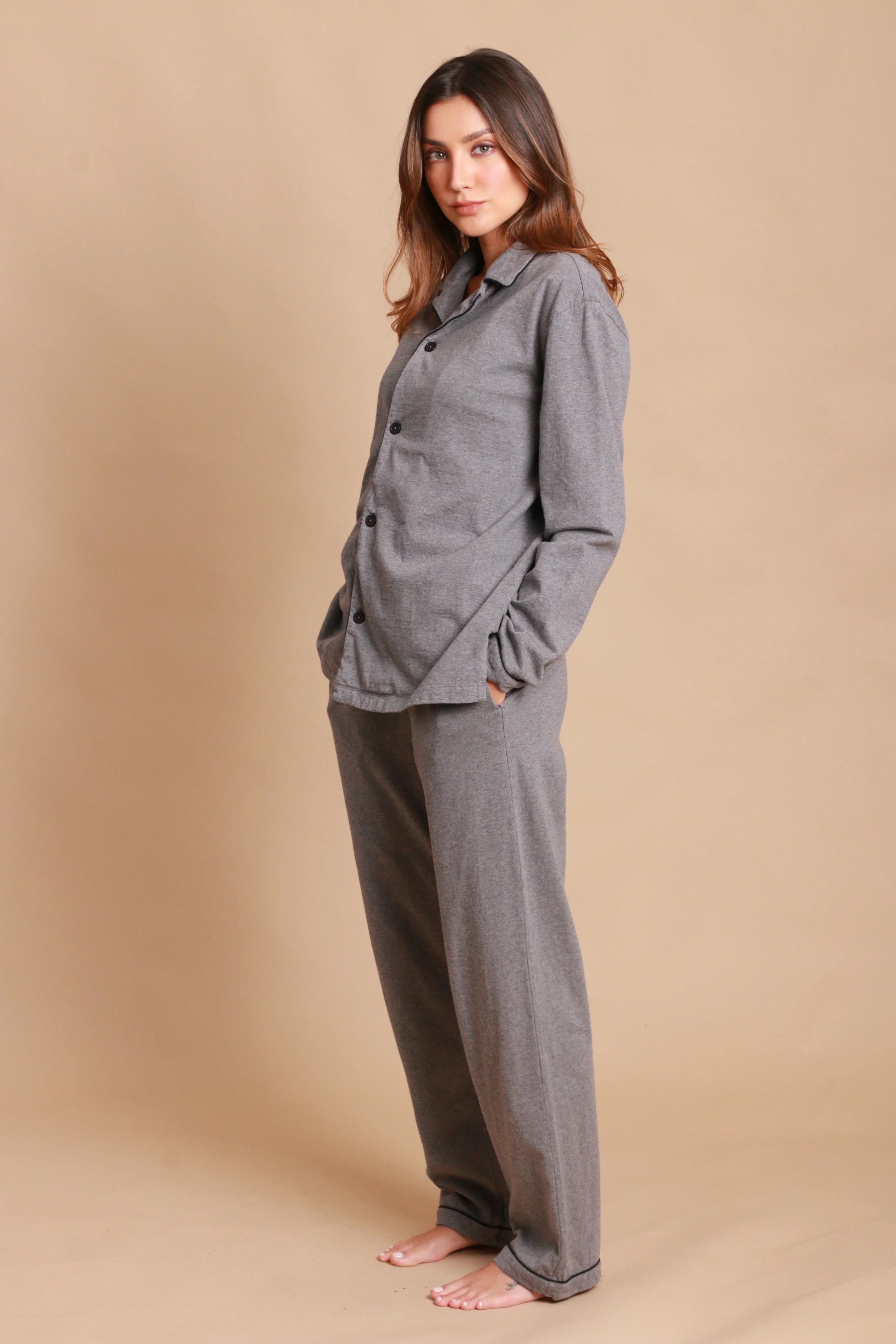 Woman wearing grey hypoallergenic cotton loungewear from Cottonique against beige background
