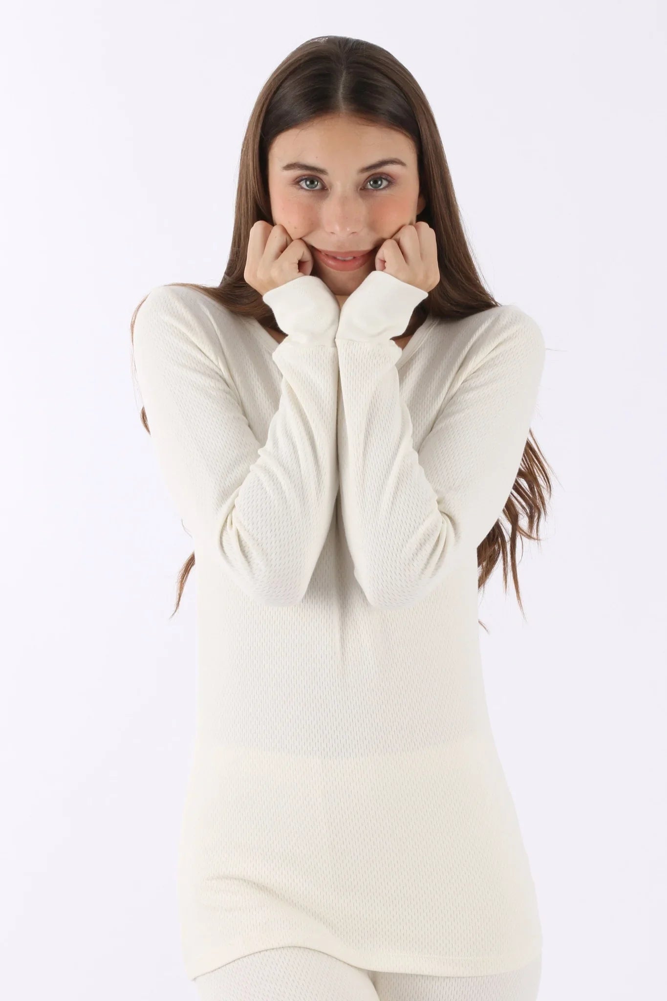 Woman wearing long sleeve, cream-colored organic cotton thermal top for sensitive skin