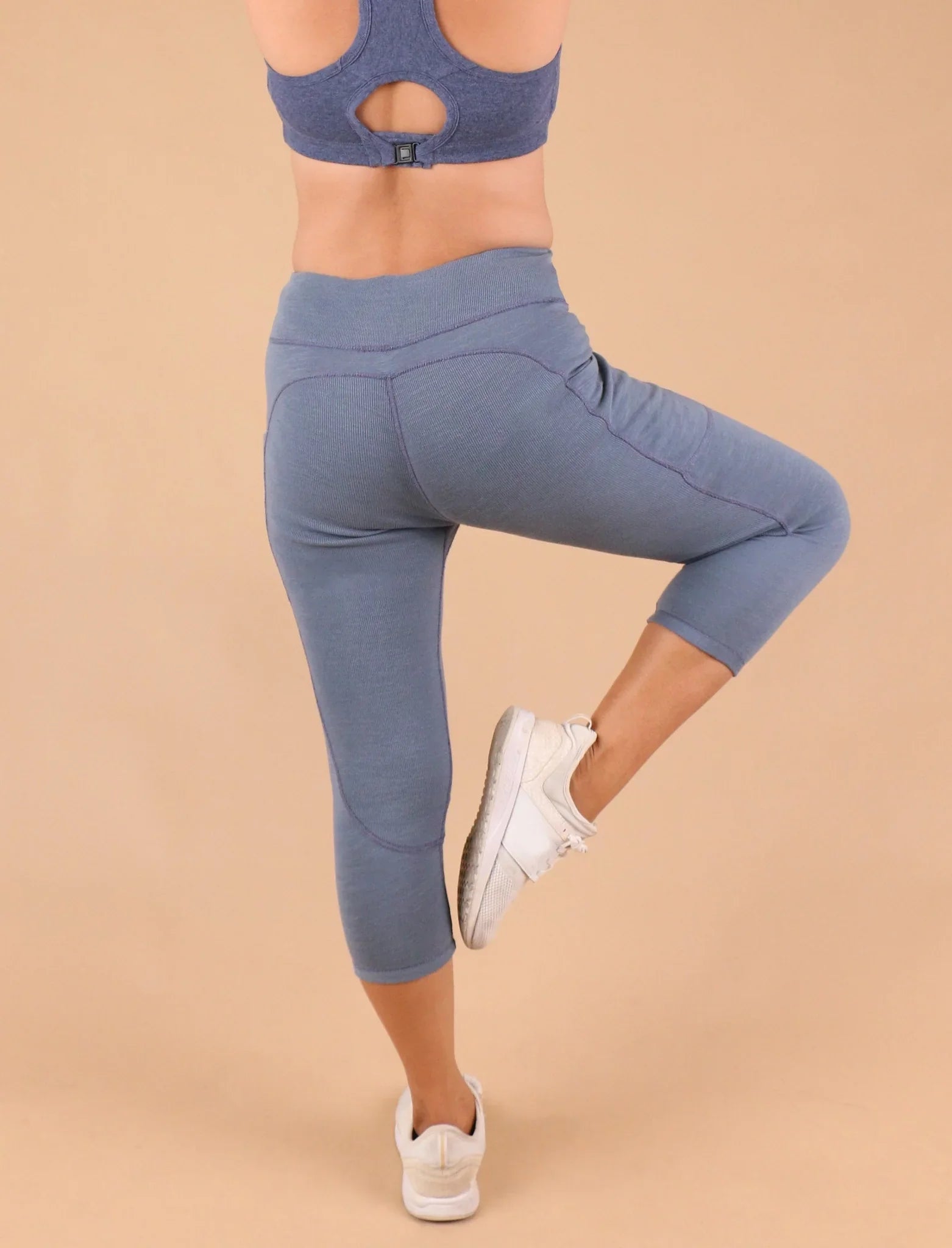 Woman wearing blue hypoallergenic cotton leggings and sports bra from Cottonique, back view