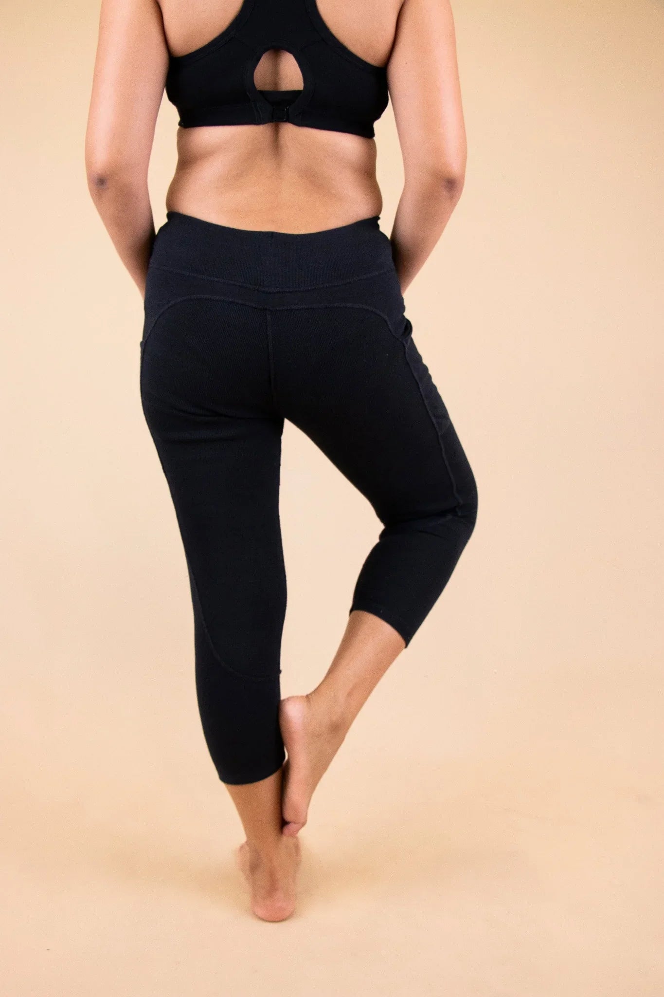 Woman wearing black organic cotton allergy-friendly cropped leggings, back view