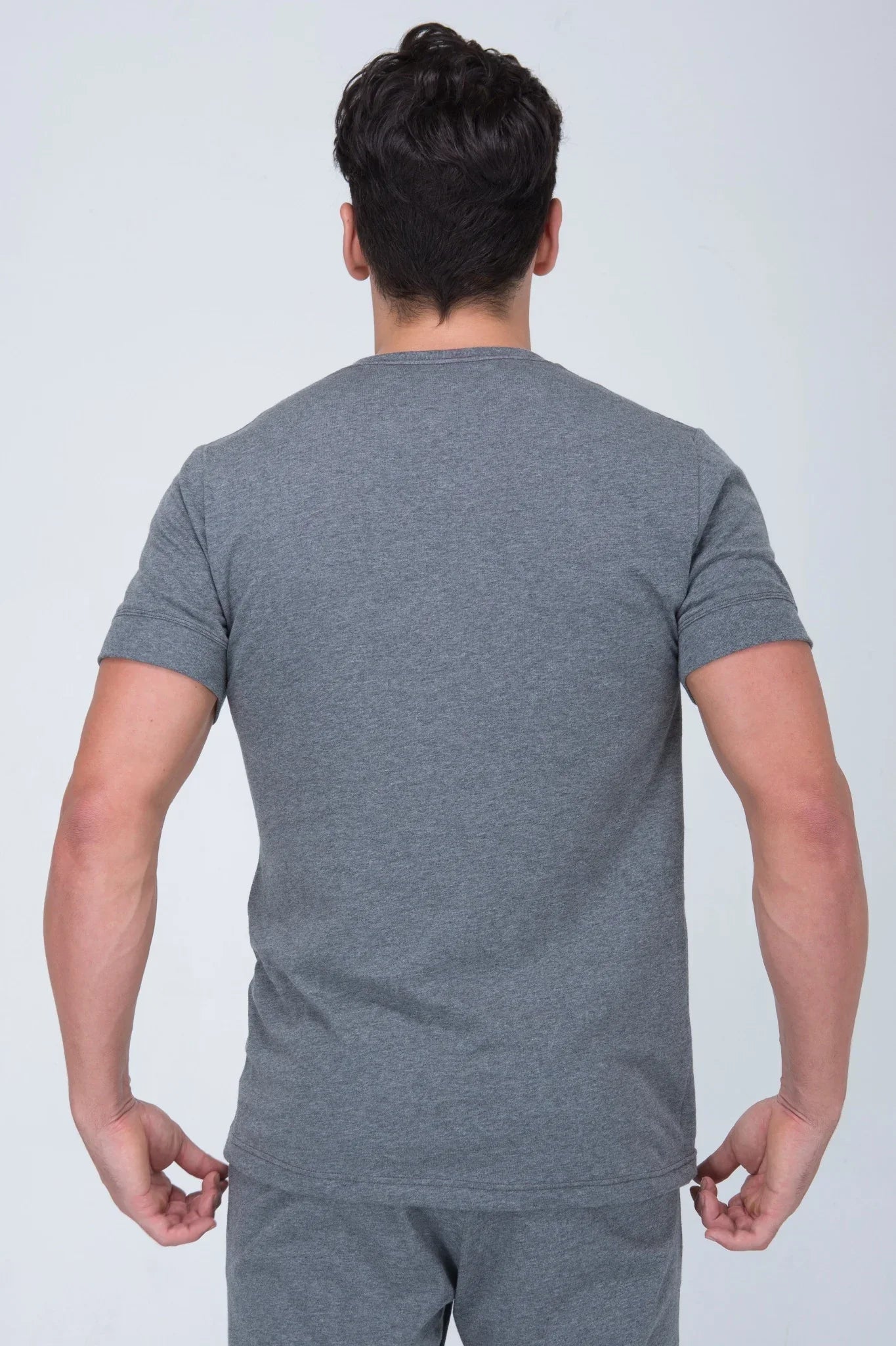 Back view of man wearing plain gray short sleeve organic cotton t-shirt and shorts