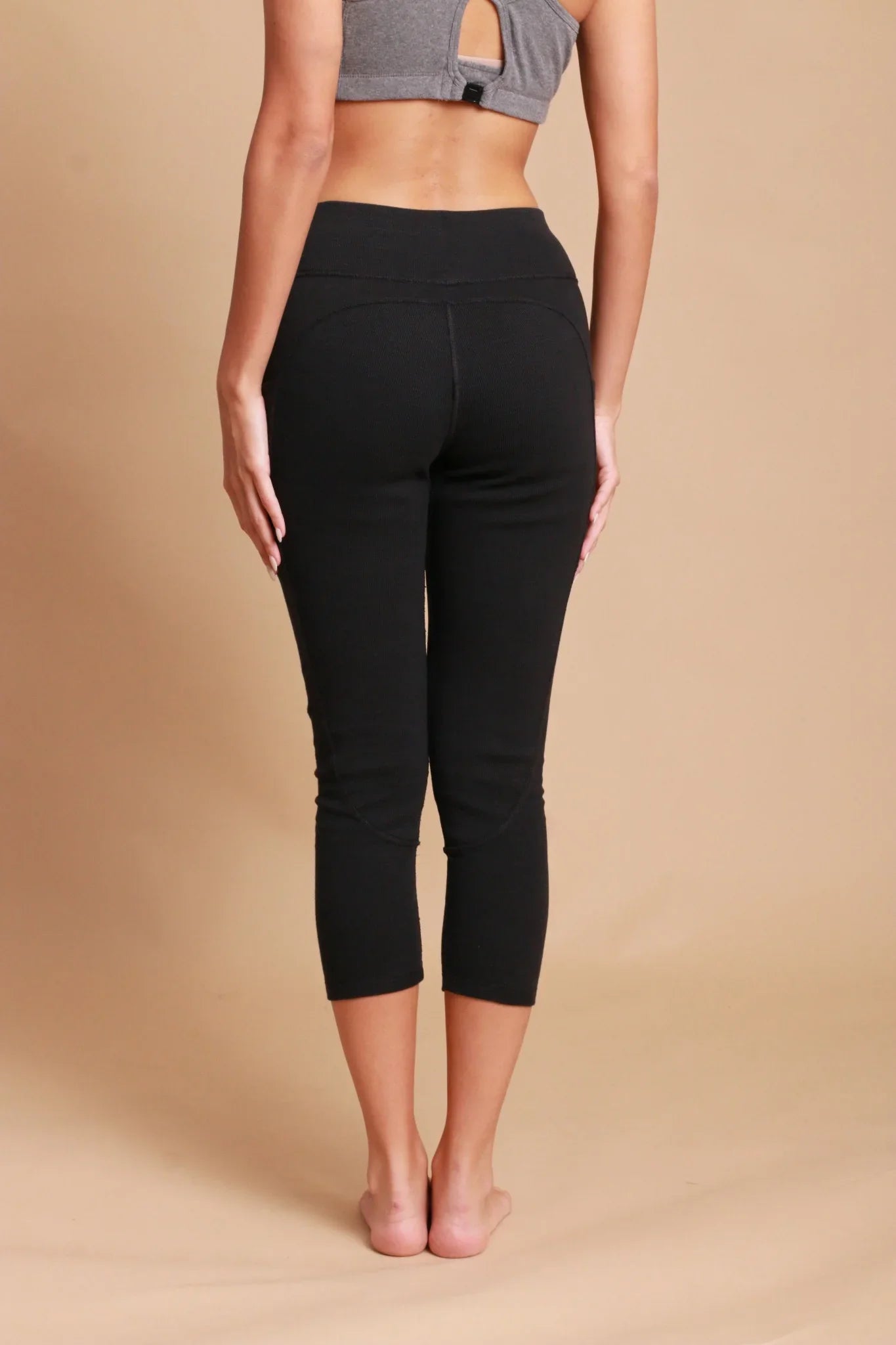 Woman wearing black organic cotton cropped leggings for sensitive skin, back view