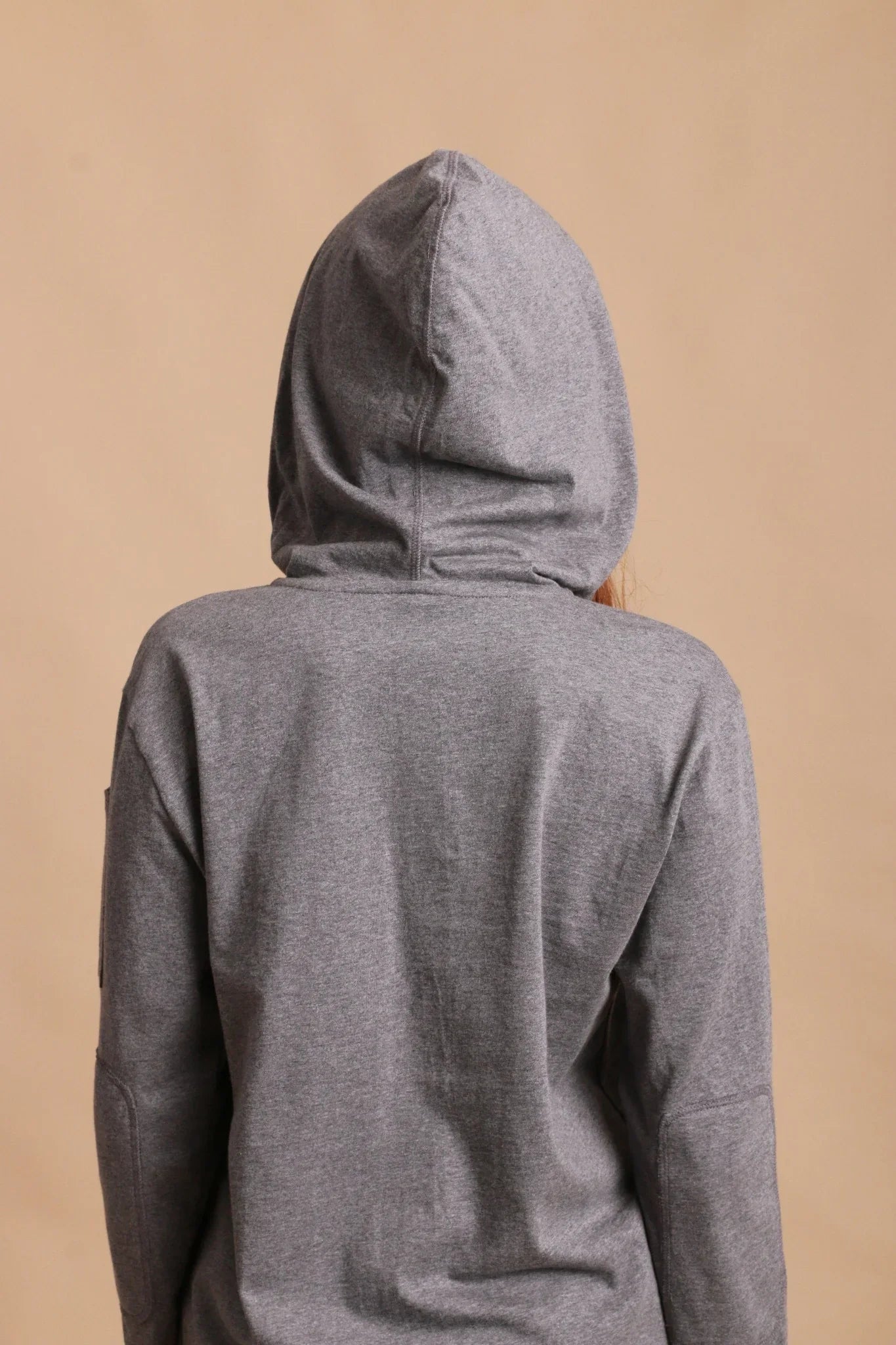 Back view of woman in gray organic cotton hoodie for sensitive skin