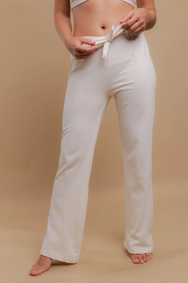 Woman wearing ivory organic cotton drawstring pajama pants for sensitive skin