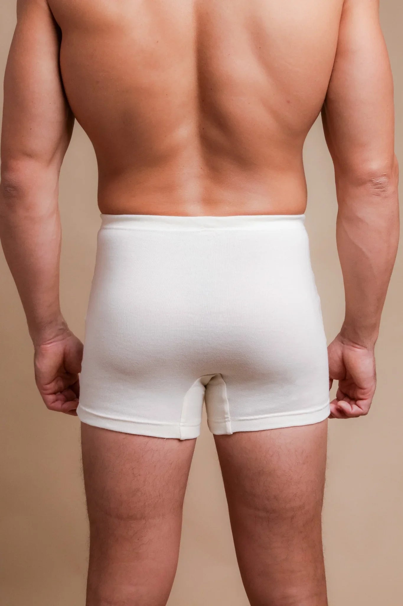Back view of a man wearing Cottonique hypoallergenic white boxer briefs