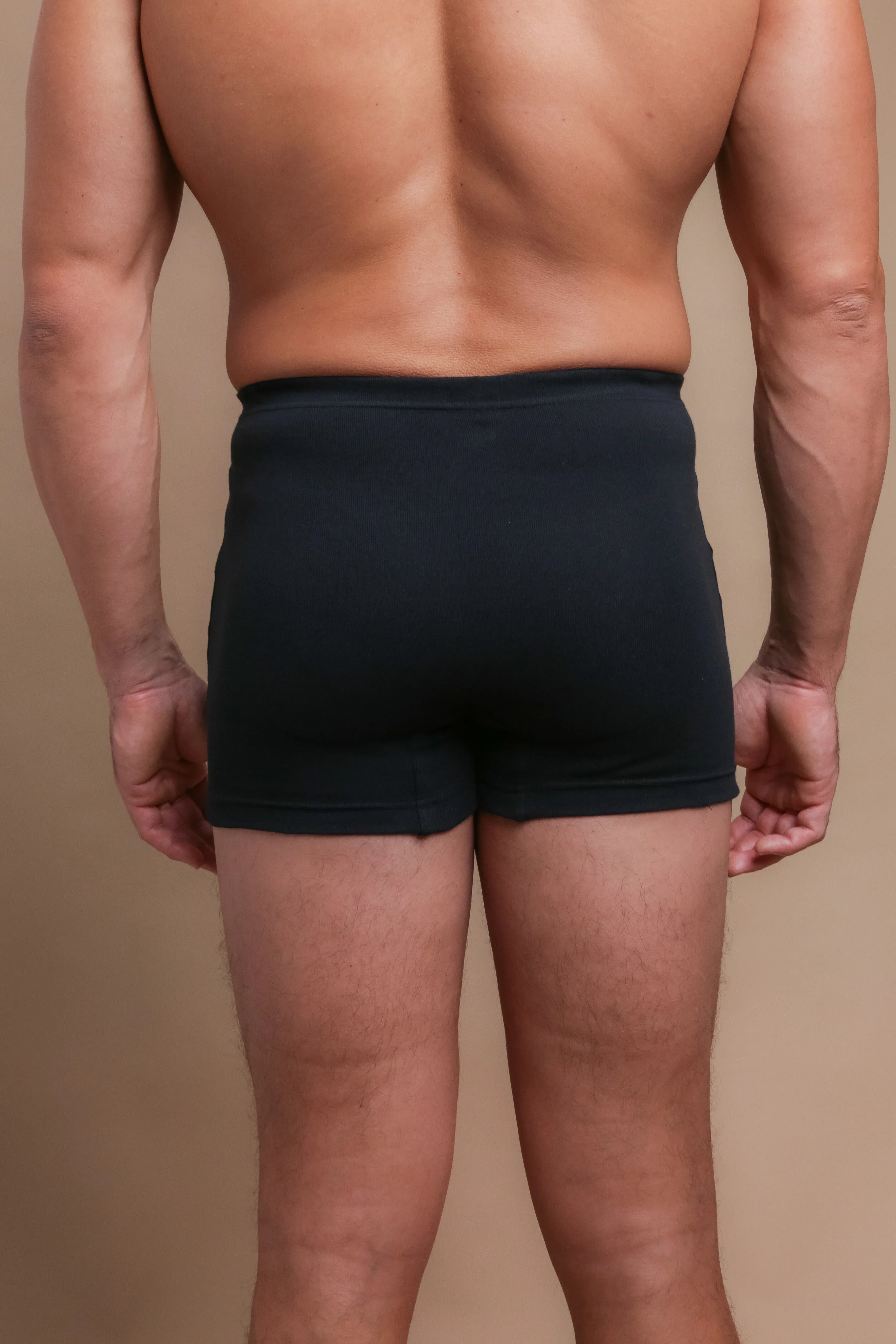 Back view of man wearing black organic cotton boxer briefs for sensitive skin