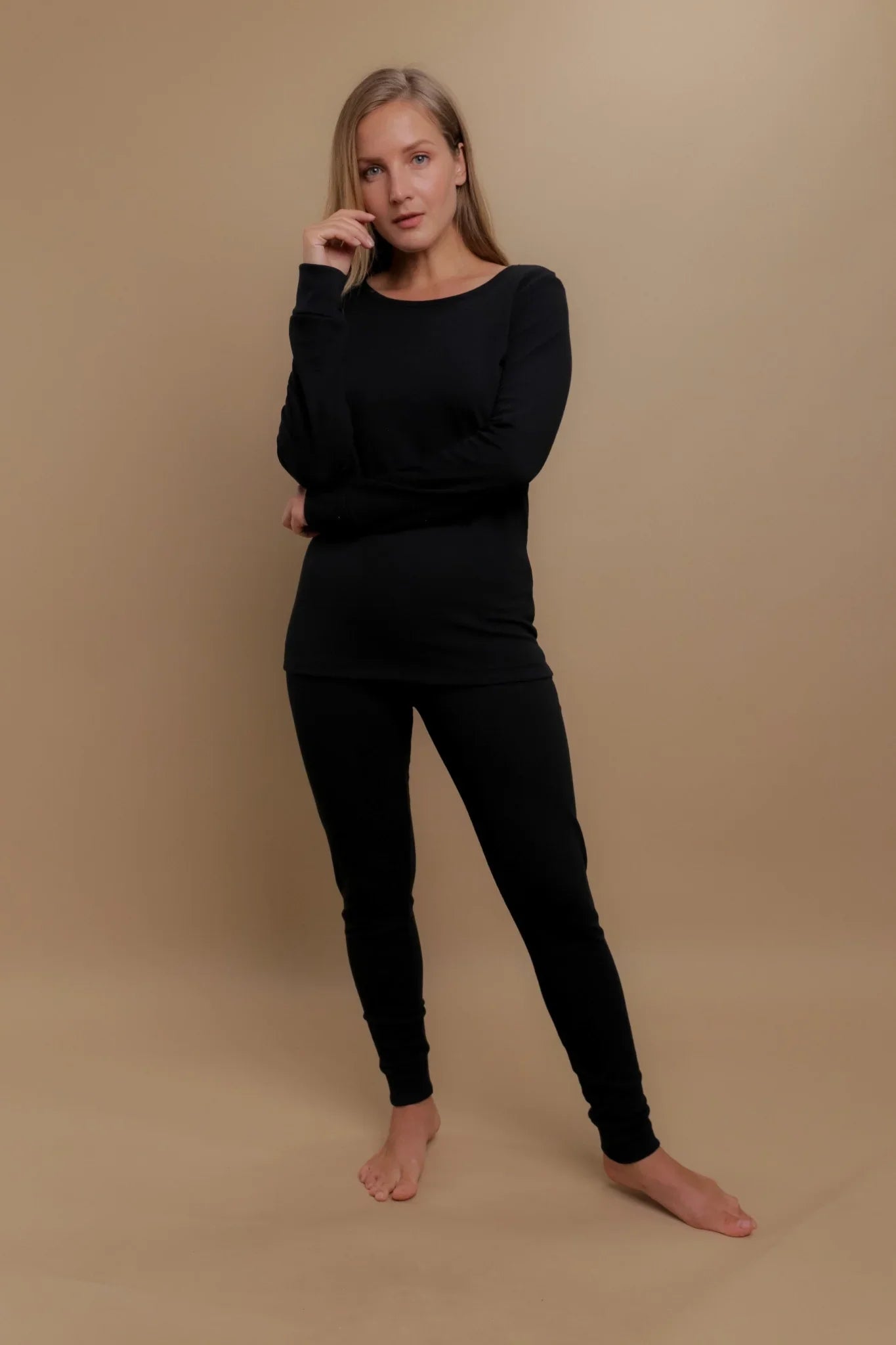 Woman modeling black hypoallergenic cotton loungewear set from Cottonique on beige background