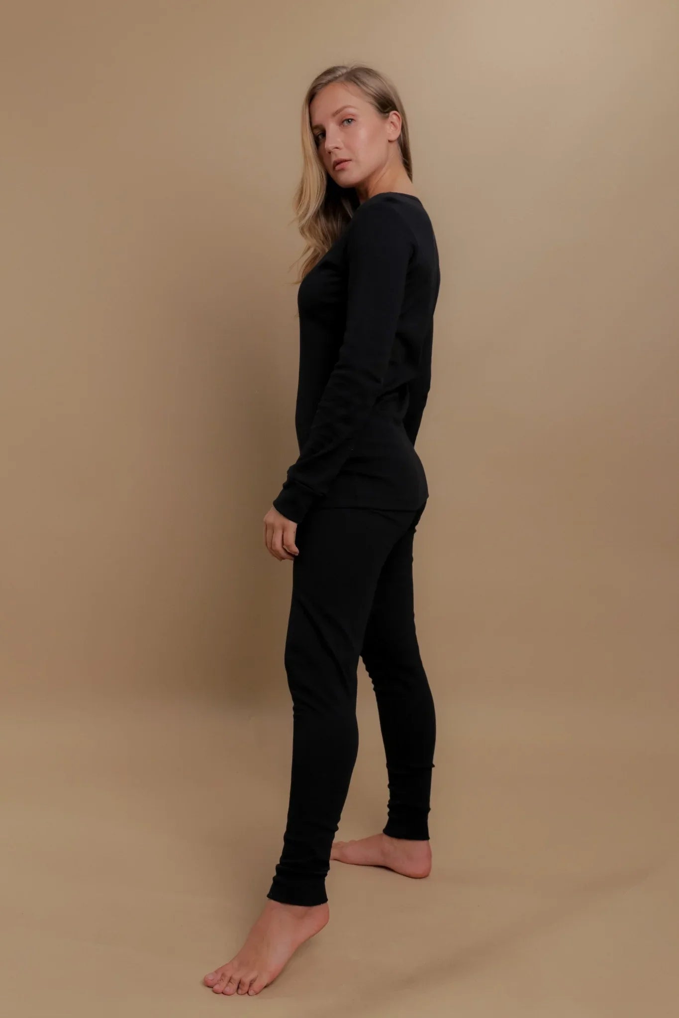 Woman in black hypoallergenic cotton long-sleeve top and leggings, allergy-free apparel