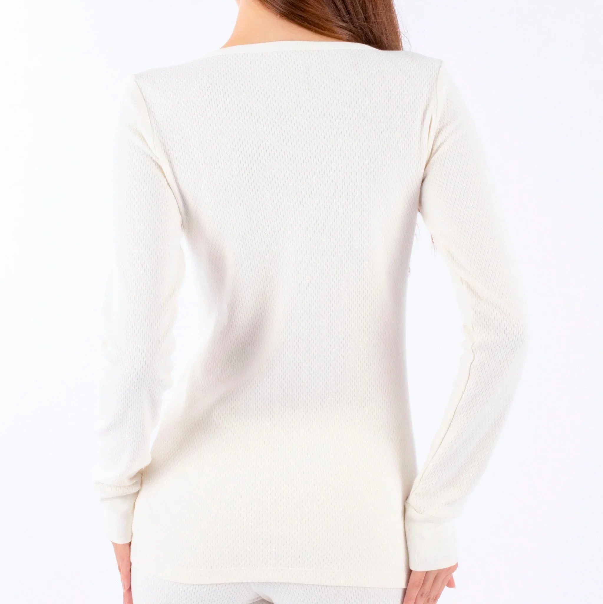 Back view of a woman wearing a long sleeve, off-white organic cotton thermal top.
