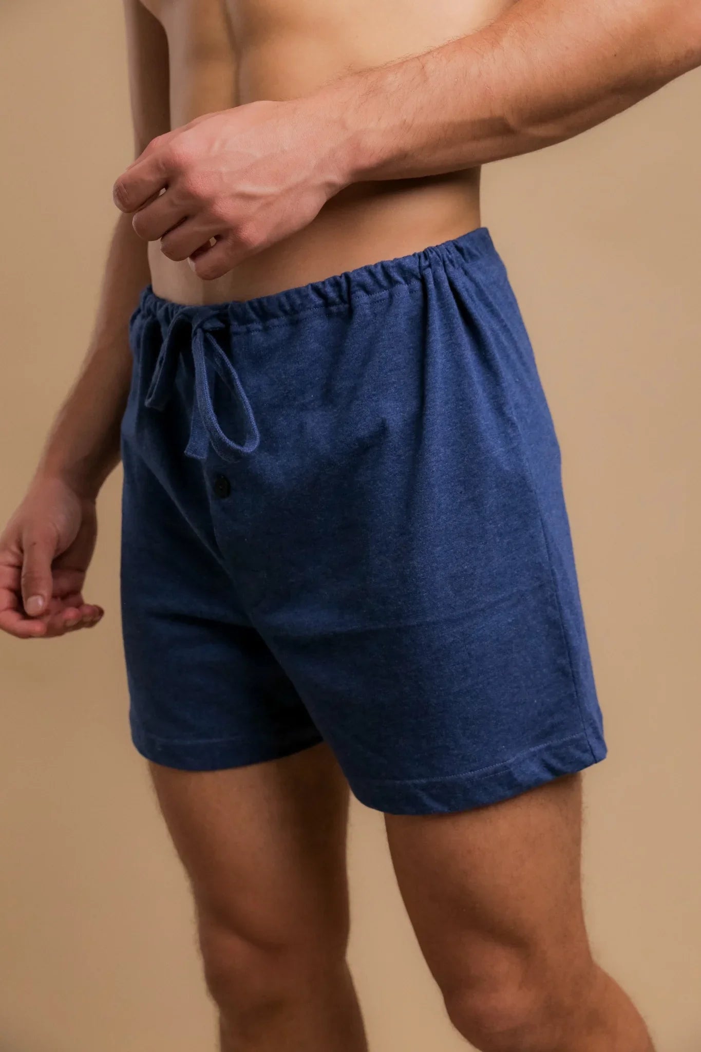Man wearing blue hypoallergenic cotton boxers by Cottonique against neutral background