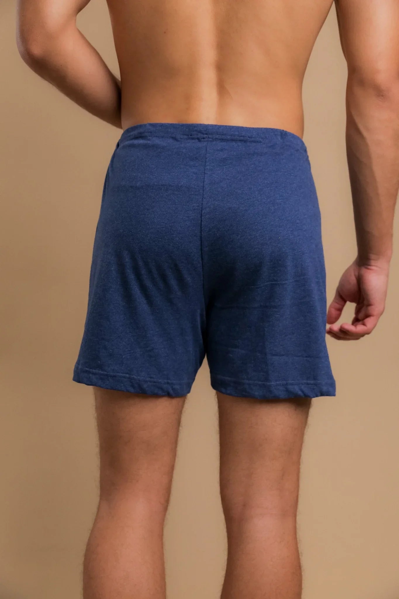 Back view of a man wearing blue hypoallergenic cotton boxer shorts from Cottonique