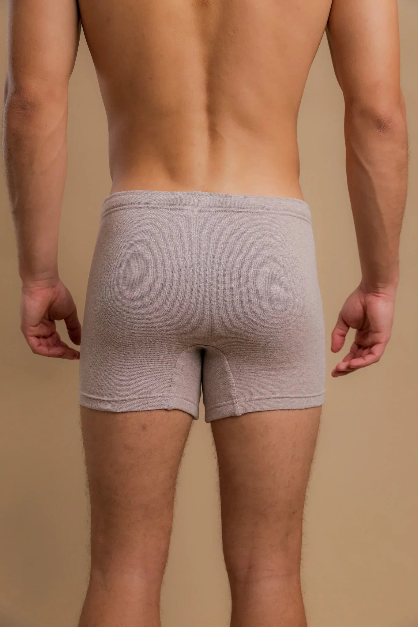 Back view of man wearing beige allergy-free cotton boxer briefs by Cottonique