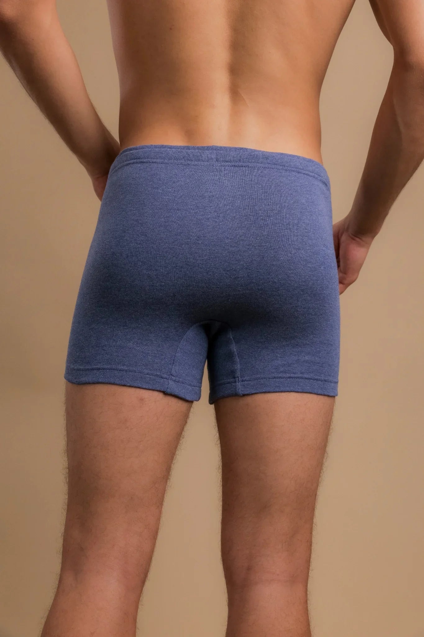 Back view of a man wearing blue hypoallergenic cotton boxer briefs from Cottonique