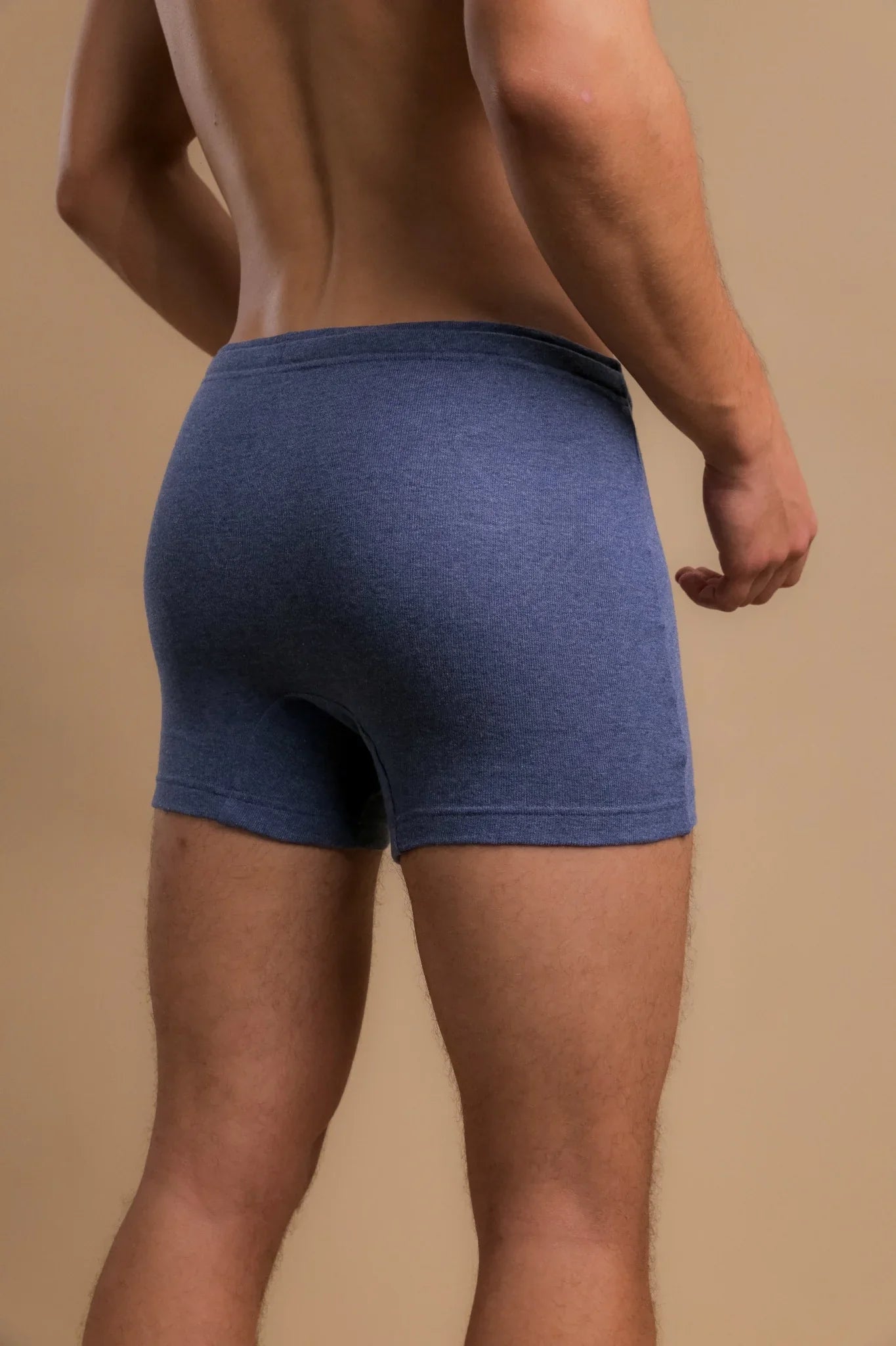 Back view of a man wearing blue hypoallergenic cotton boxer briefs from Cottonique